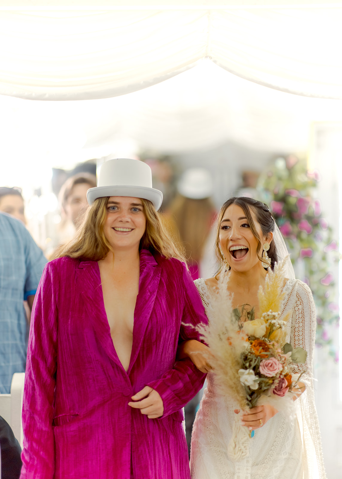 Bride walking down aisle with guest dressed in 70's attire 