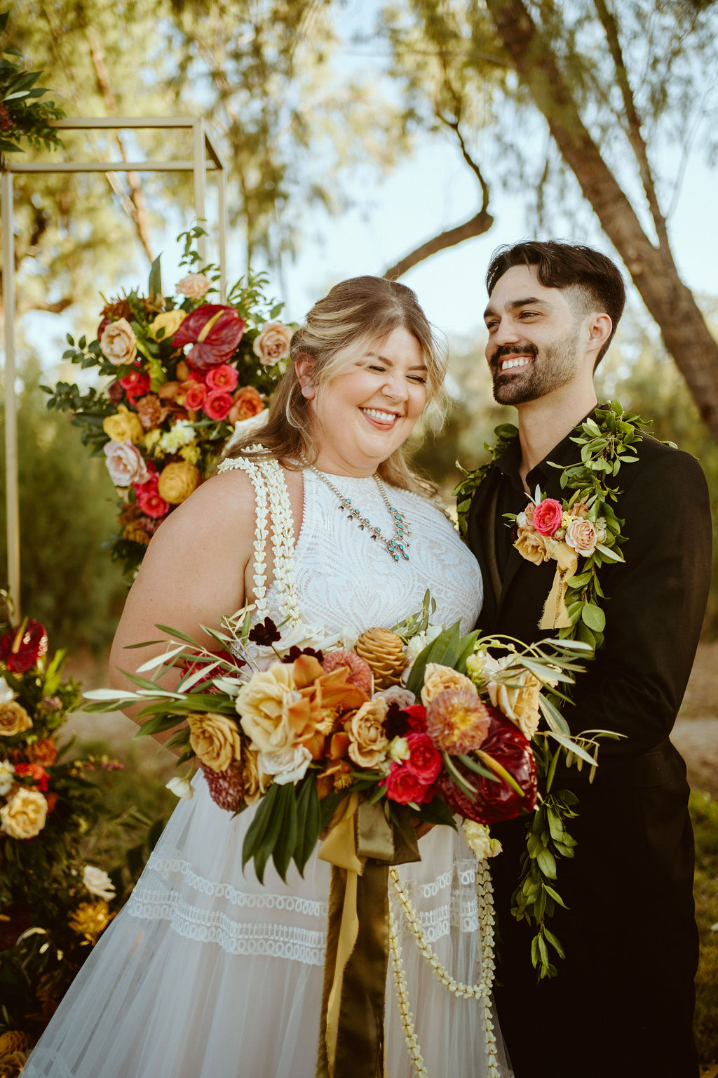 Newlyweds Laughing with Hawaiian Inspired Bouquet and Leis after GreenGale Farms Hawaiian Elopement in Las Vegas 