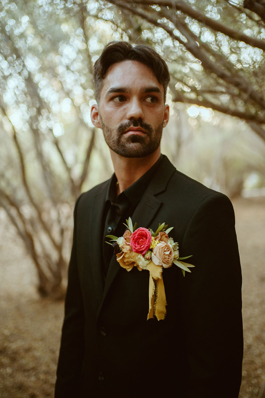 Groom in all Black suit in Olive Grove for GreenGale Farms Hawaiian Elopement 