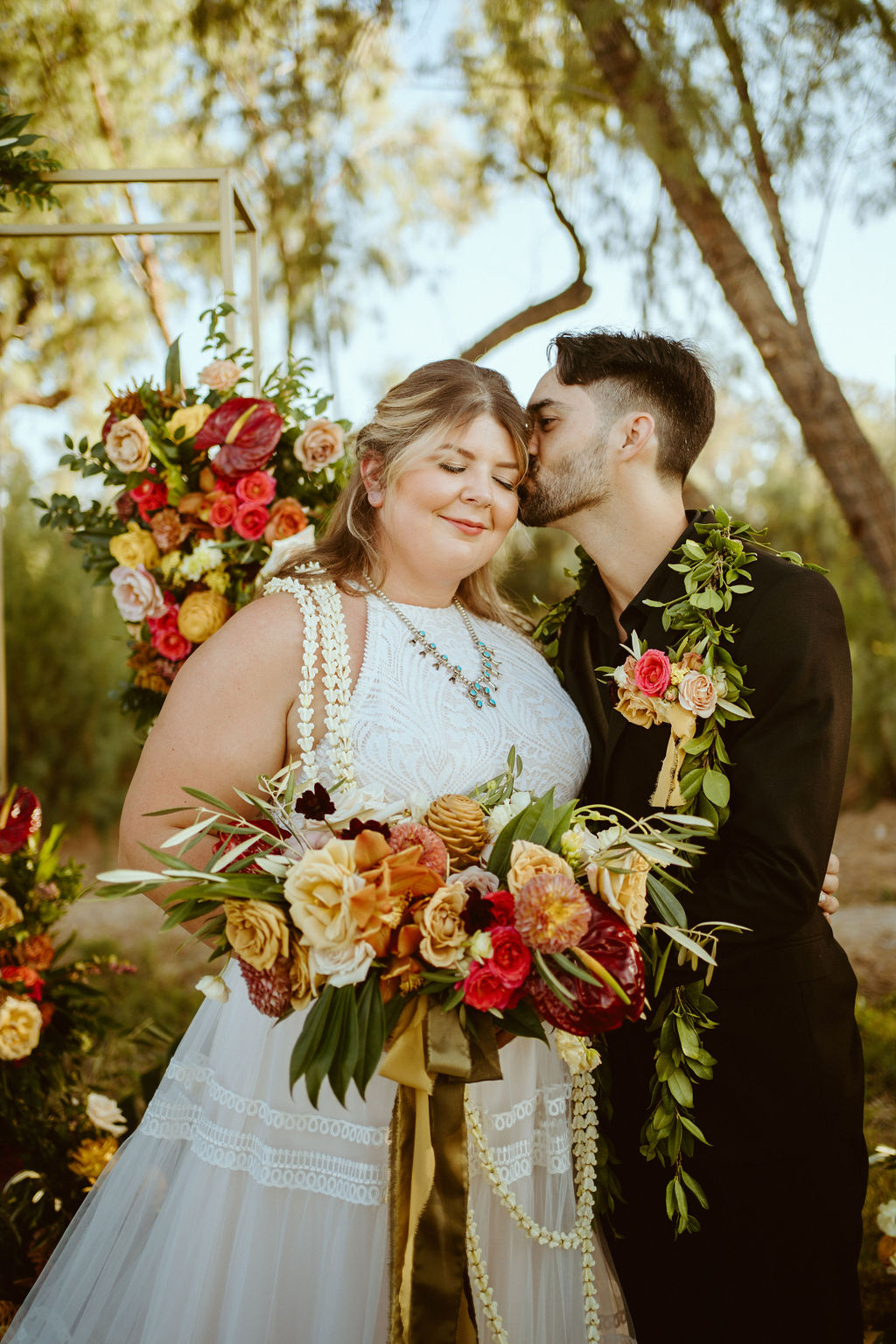 Groom Kissing Bride with Hawaiian Inspired Bouquet and Bridal Lei 