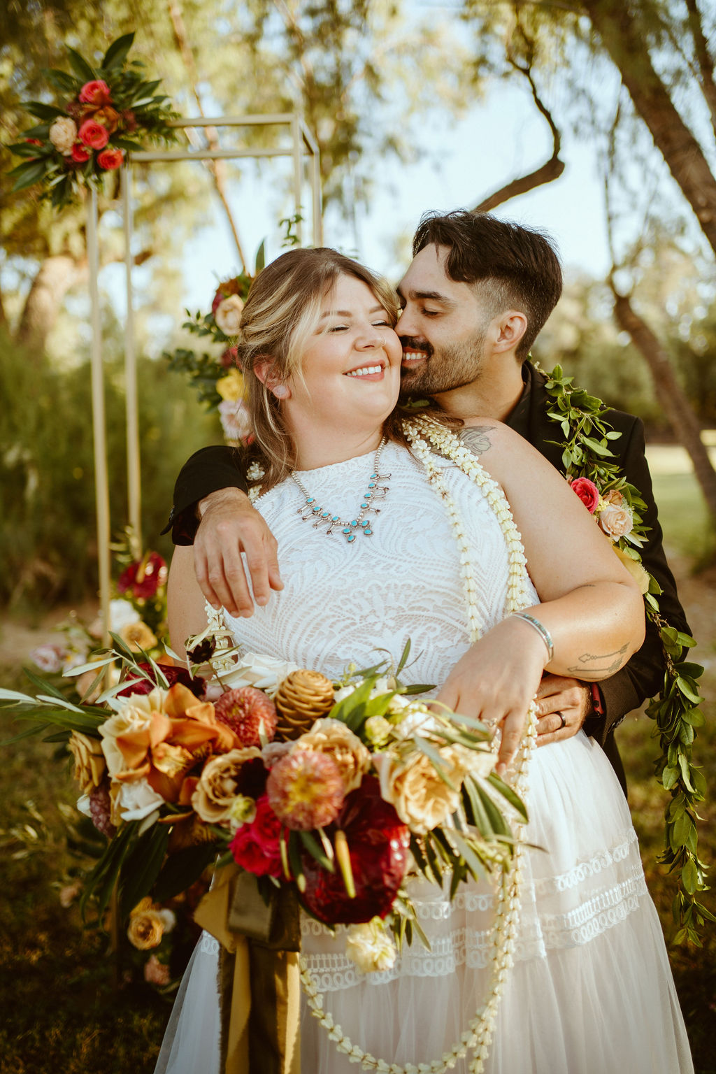 Groom Hugging Bride with Hawaiian Inspired Bouquet and Bridal Lei 