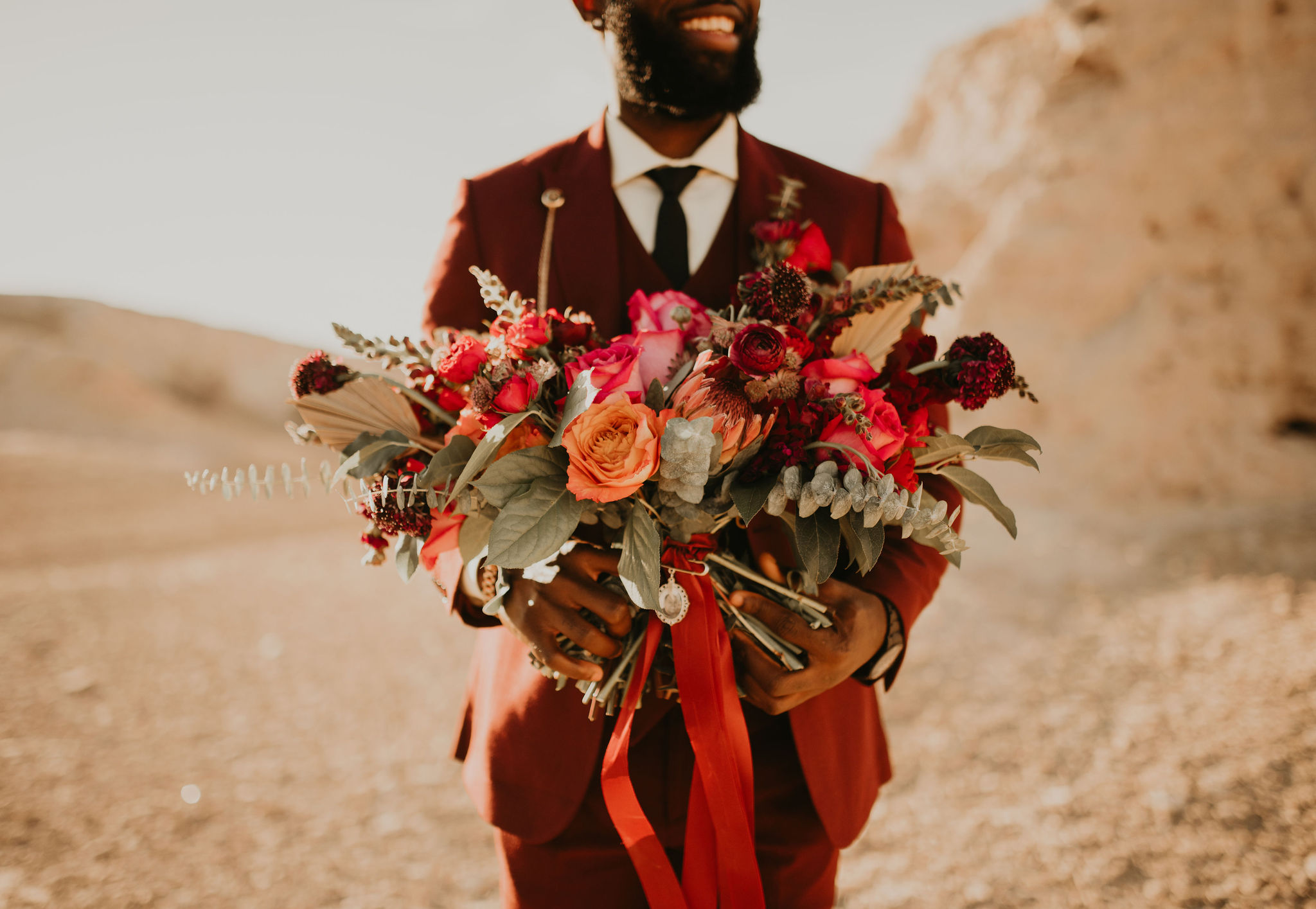 Groom in Burgundy Suit hold Brides Jewel Tone Bouquet with Bridal Pendant 