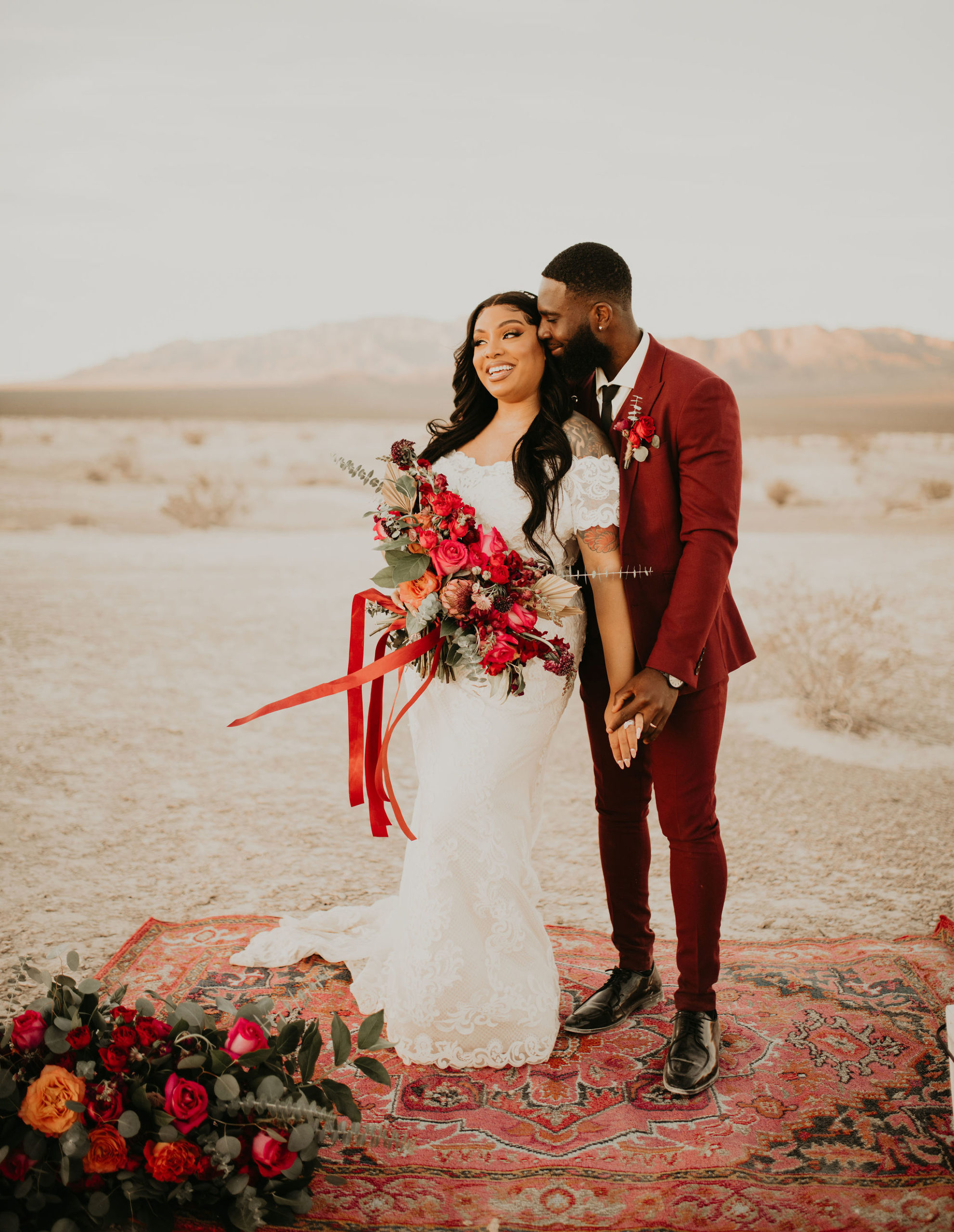 Newlyweds on Rug with Ground Florals in Jewel Tone Las Vegas Elopement