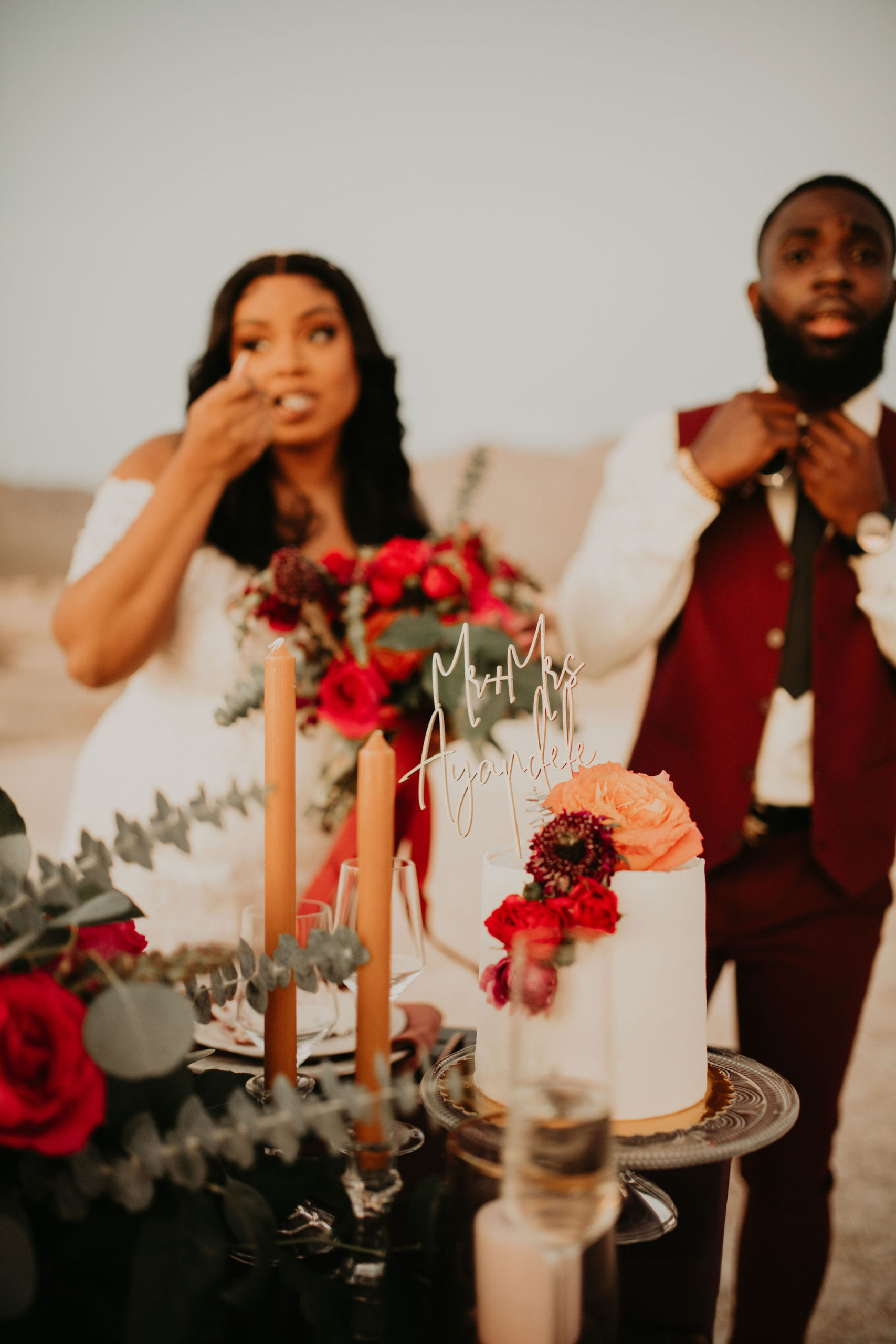 Couple Enjoying Cake with Cake Topper at Sweetheart Table in Jewel Tone Las Vegas Elopement