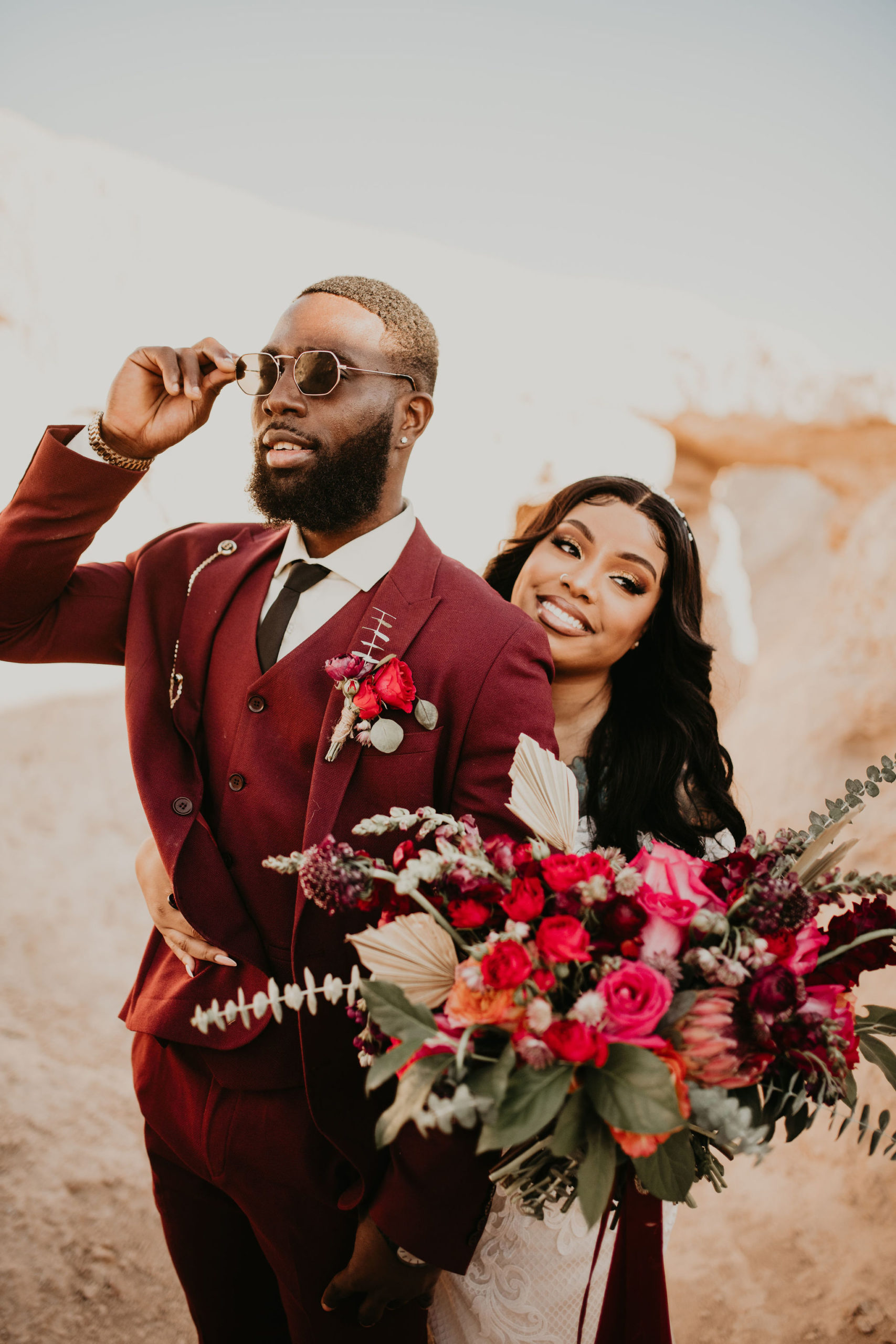 Groom with Burgundy Suit and Sunglasses & Boutonnière with Bride in Glam Make-up and Bouquet 