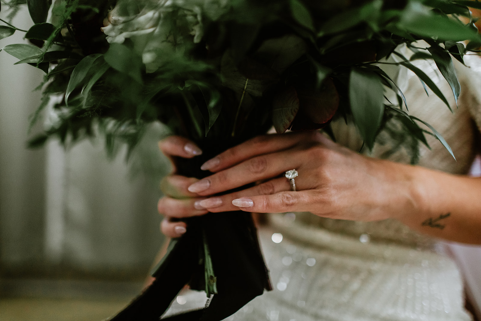 Brides hands & ring holing on to bouquet 