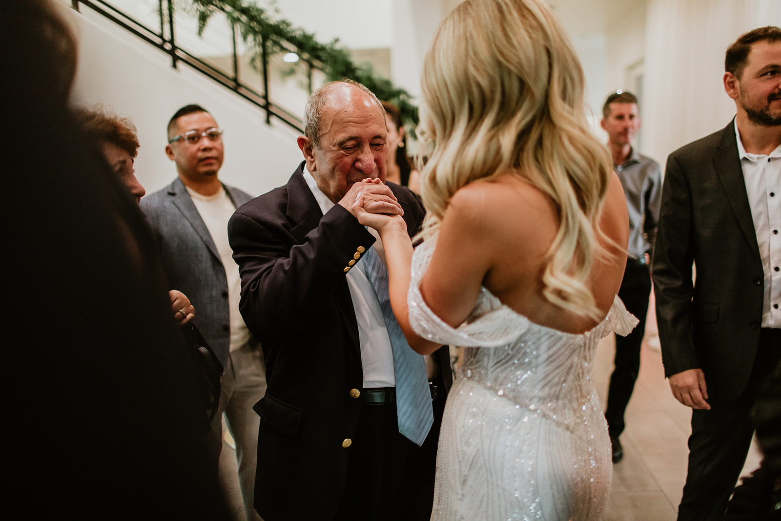 Guest Kissing Brides Hand at Cocktail Hour 