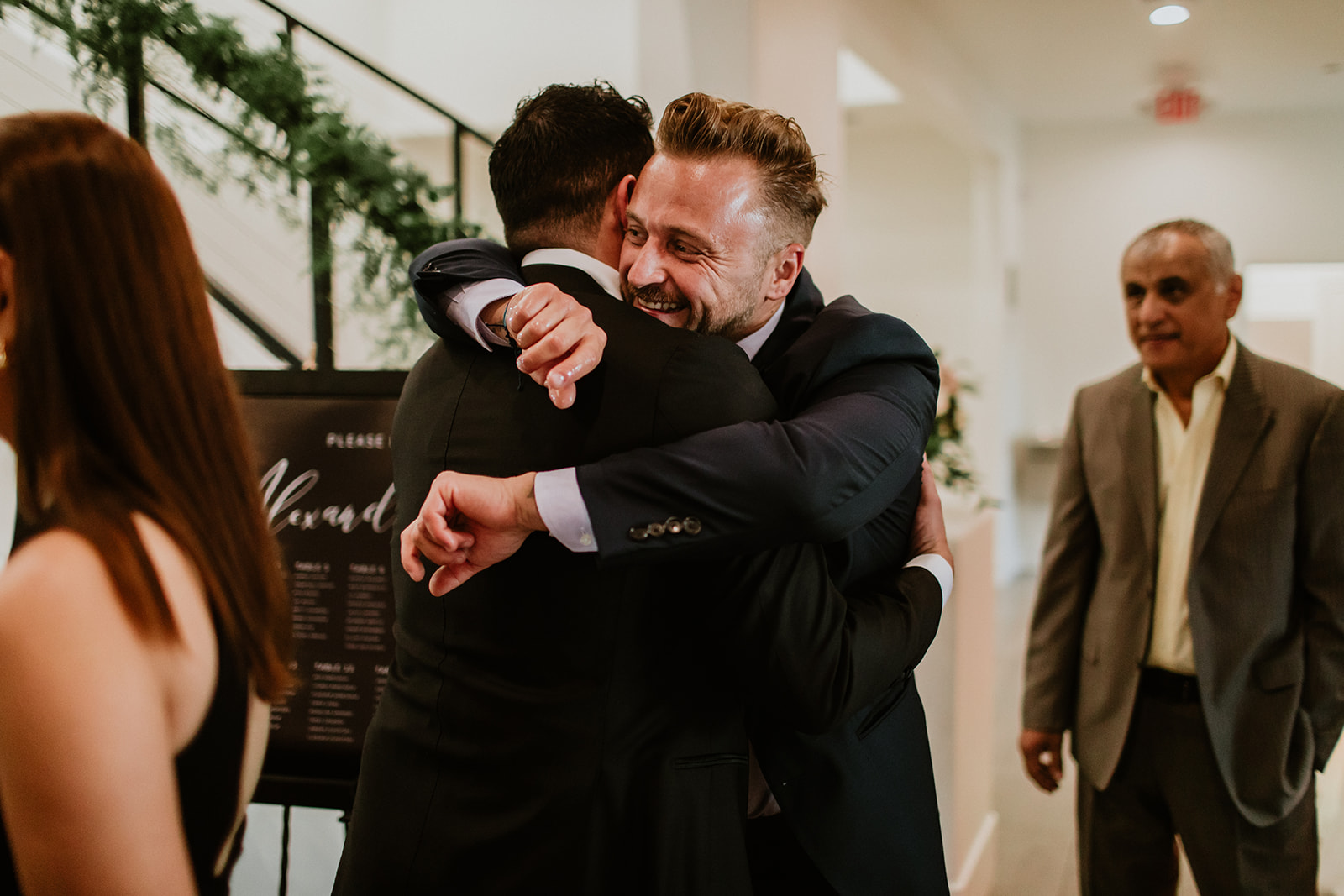 Groom Hugging Guest at Cocktail Hour 