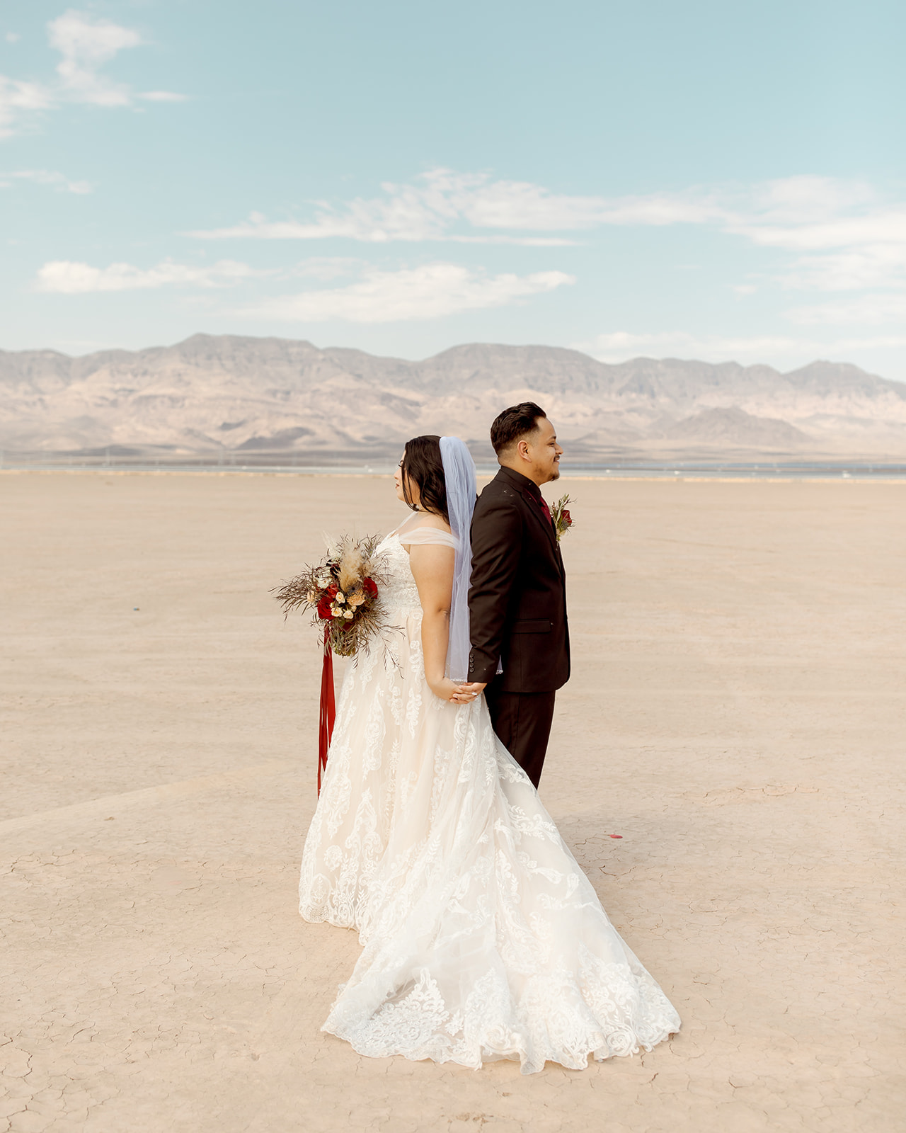 Couple Standing Back to Back after Moody Dry Lake Bed Elopement 