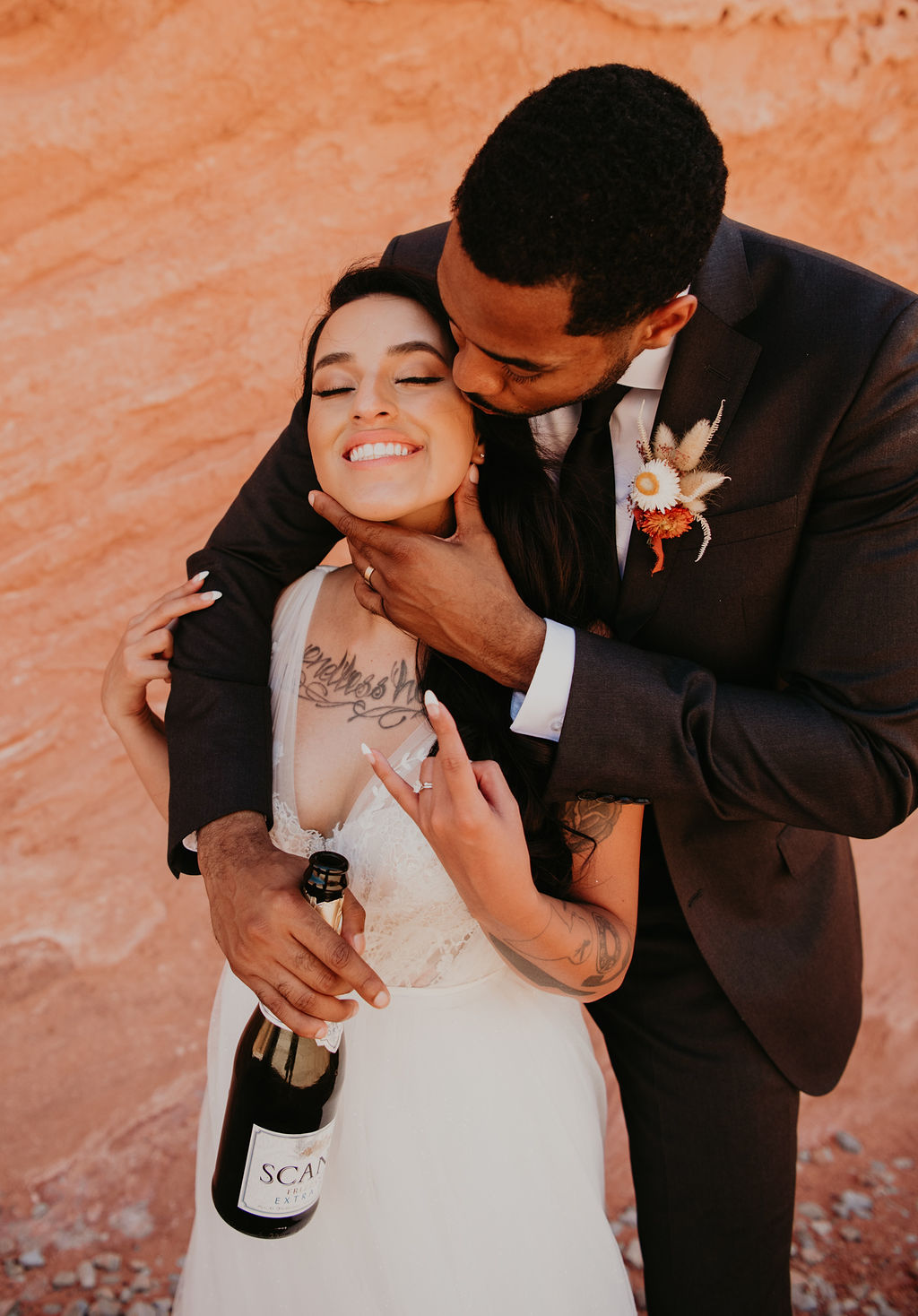 Groom Holding Bride's Face and Kissing her Cheek in Valley of Fire 