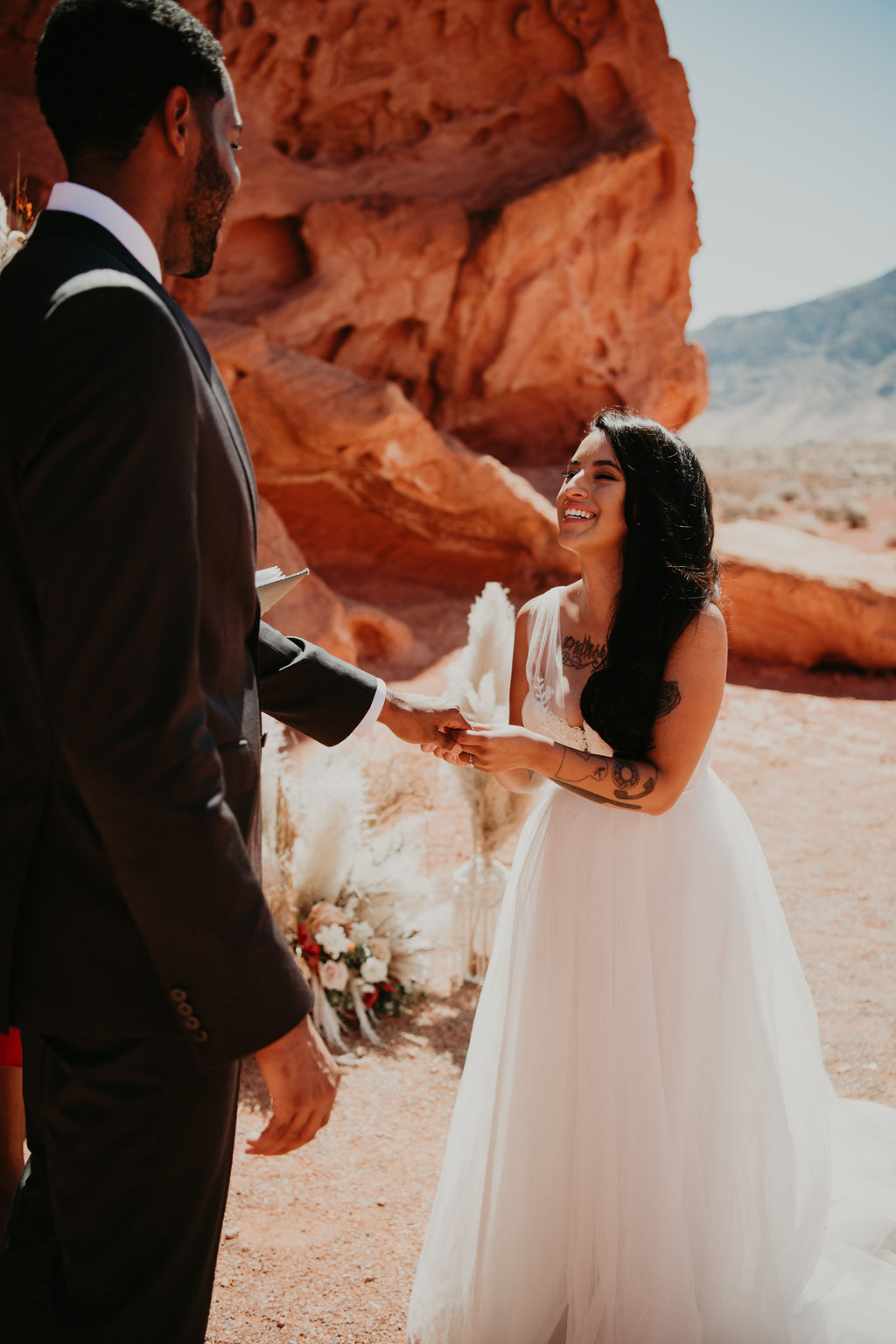 Bride Smiling and Laughing Wile Putting Ring on Grooms Finger in Off the Strip Las Vegas Wedding