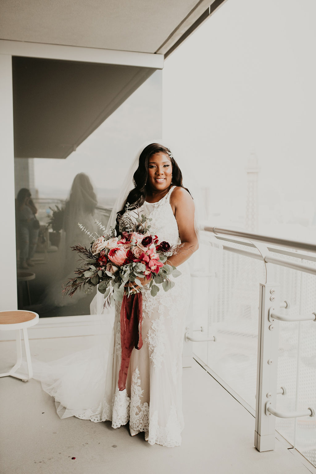 Bride Smiling on Balcony at The Cosmopolitan Las Vegas in Rustic Pink Burgundy and Sage Elopement 
