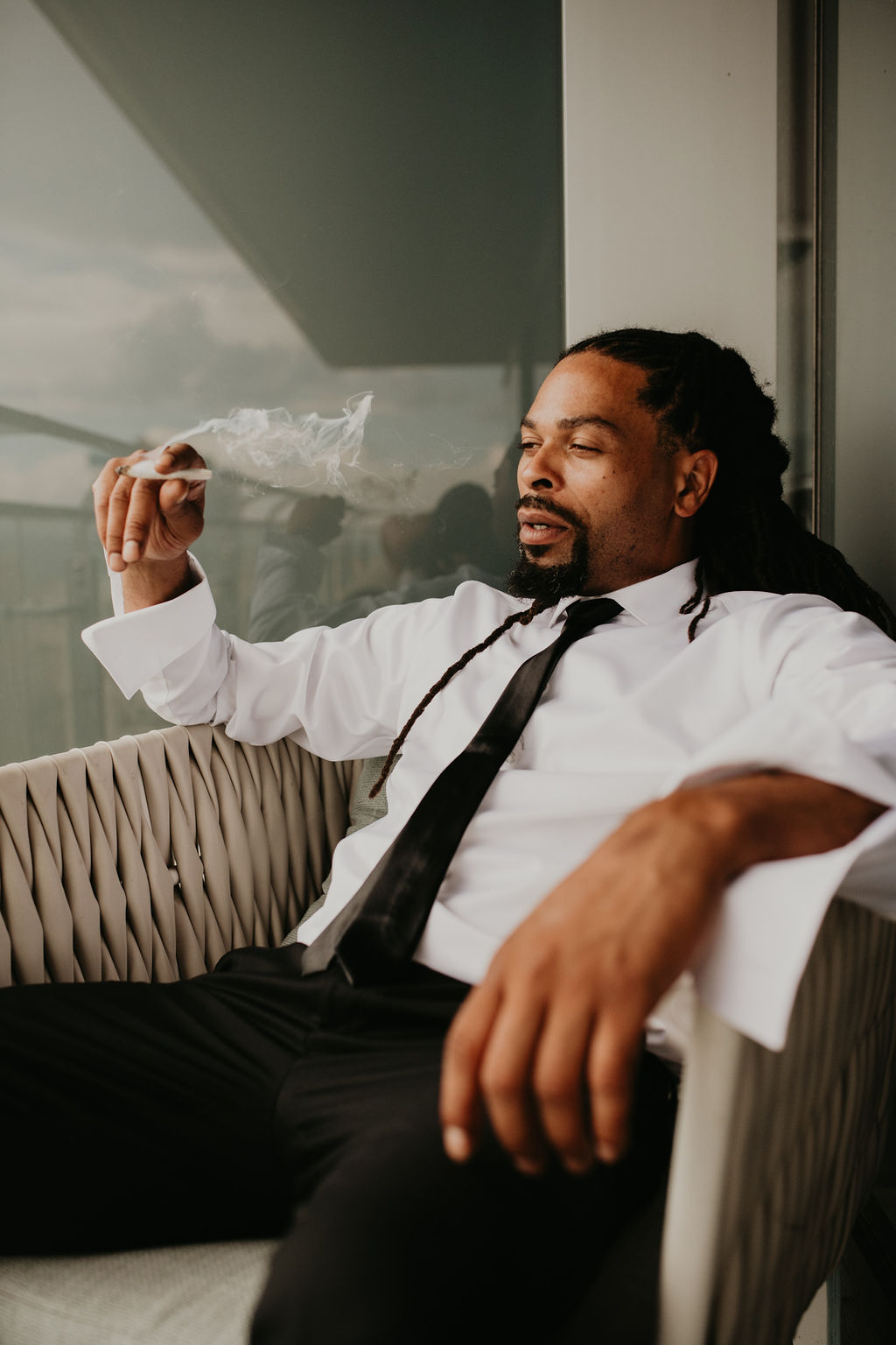 Groom Smoking while Getting Ready Before Elopement 