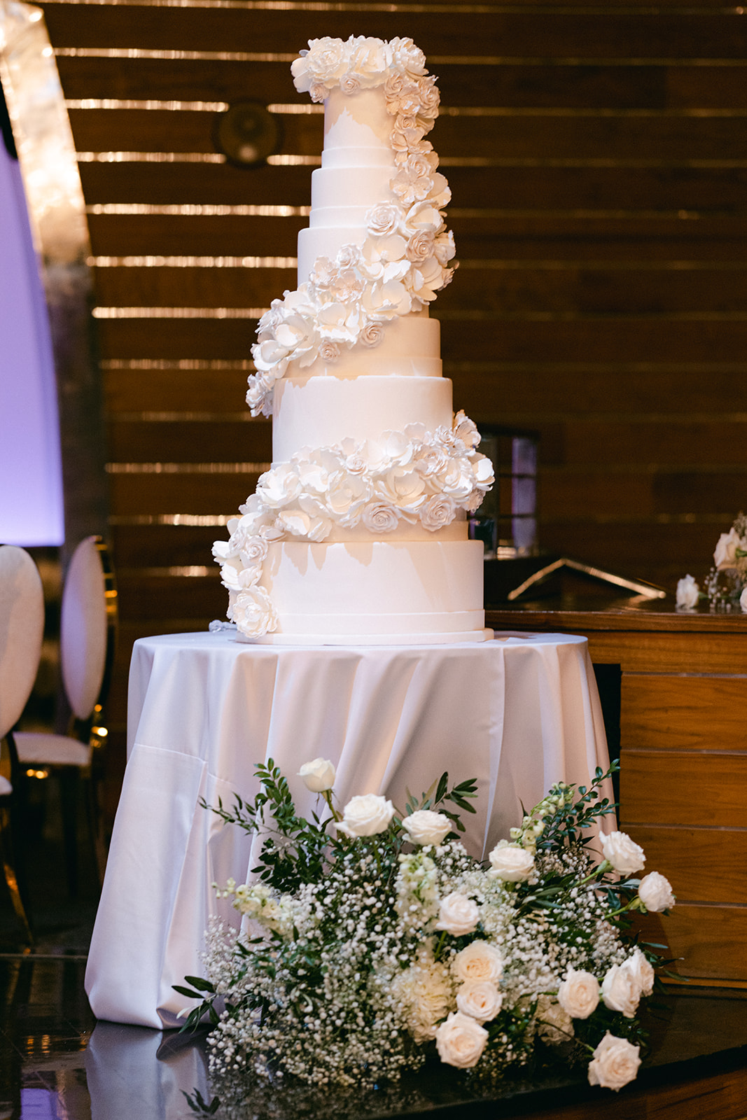 Tall white wedding cake with floral design 