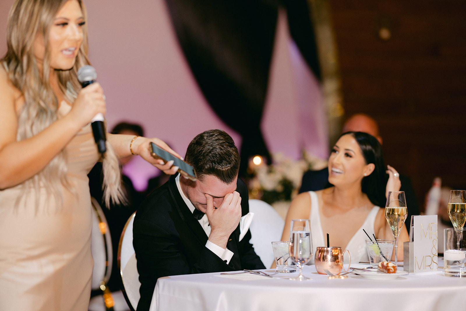 Newlyweds laughing during speech 