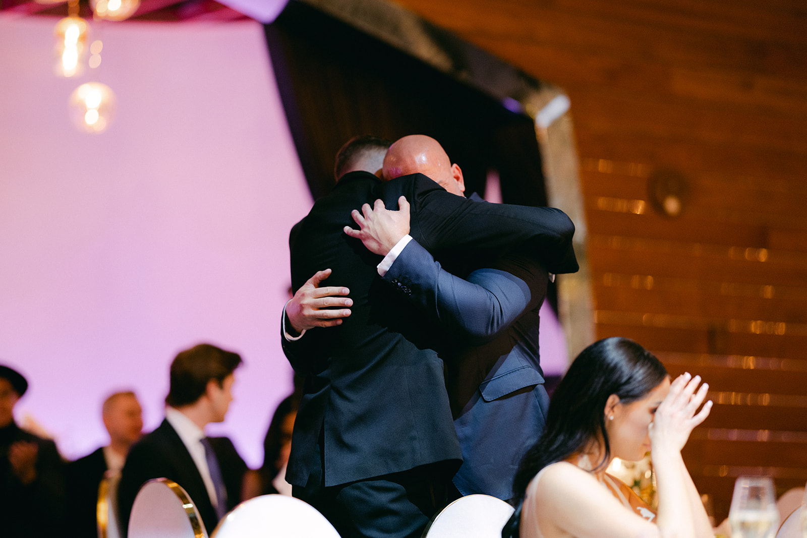Father hugging groom after reception speech