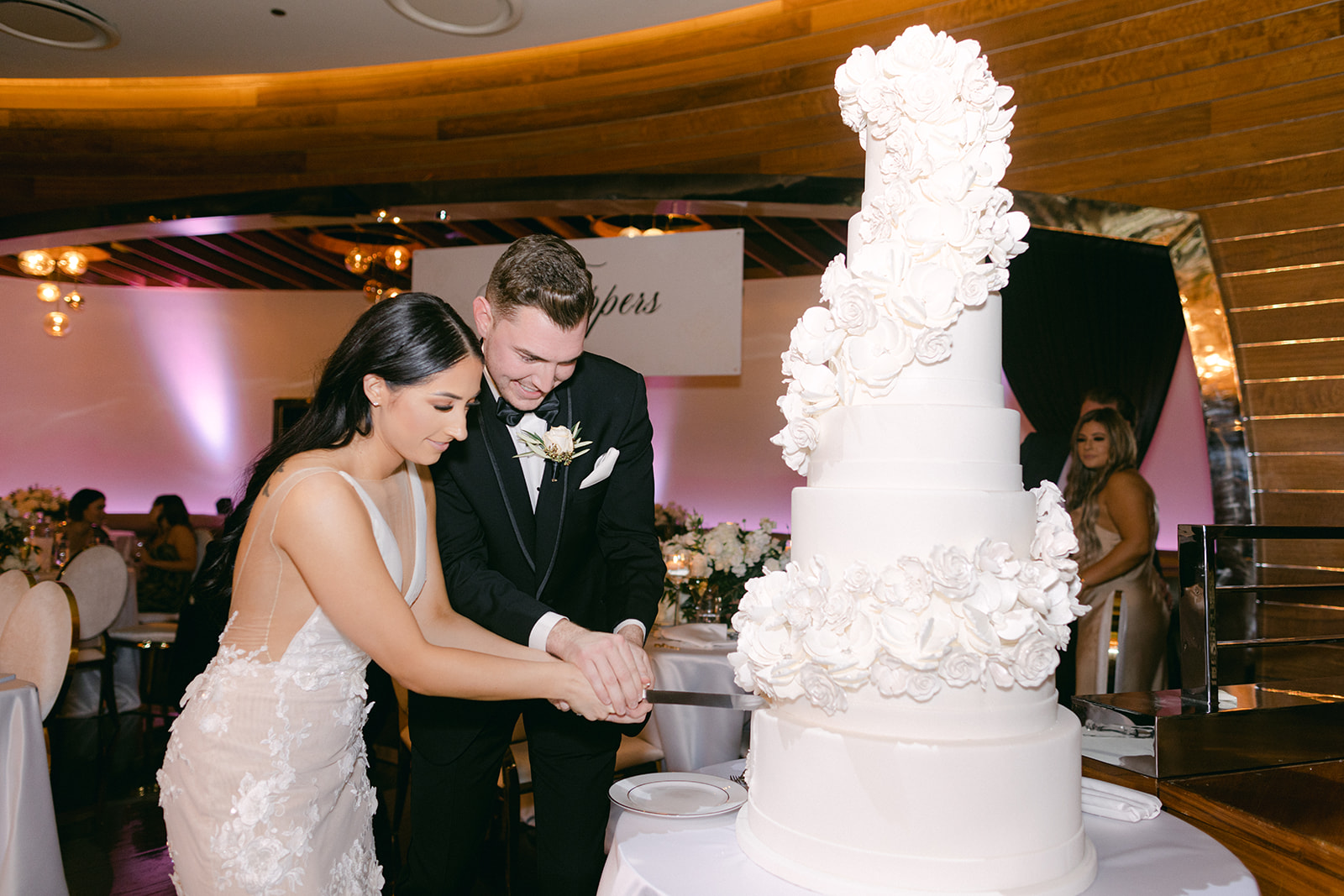 Couple cutting tall white and rose cake for Red Rock Casino Timeless Modern Wedding 