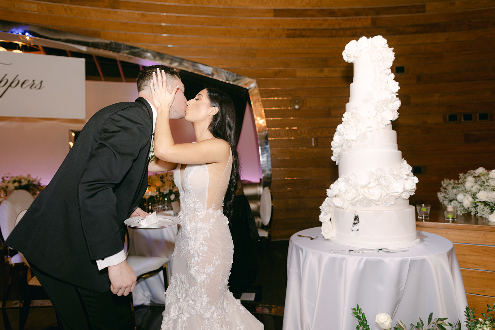 Couple kissing after cutting cake at reception 