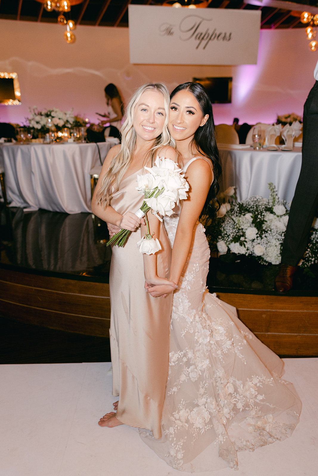 Bride with bridesmaid during reception 