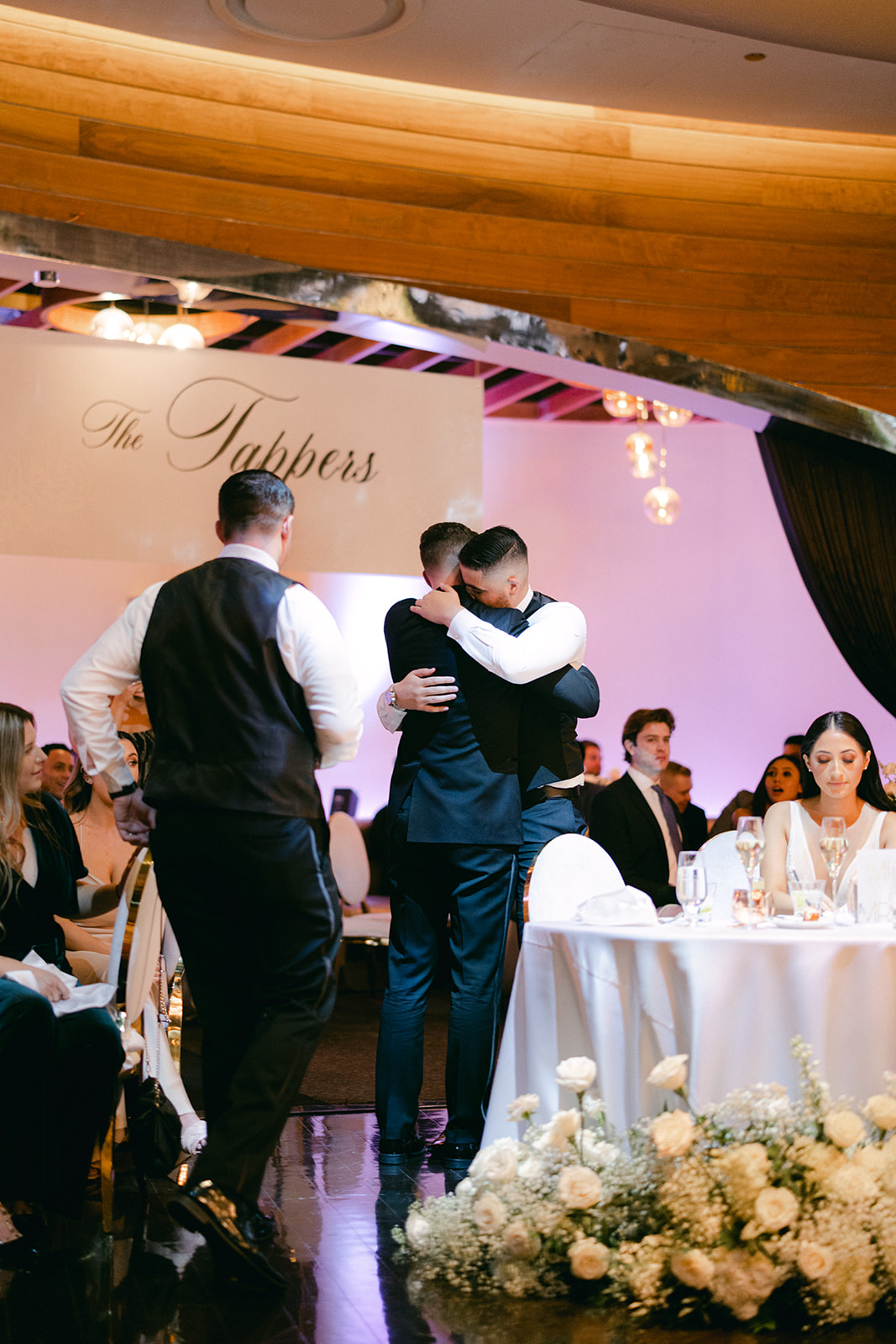 Groomsmen hugging groom during reception 