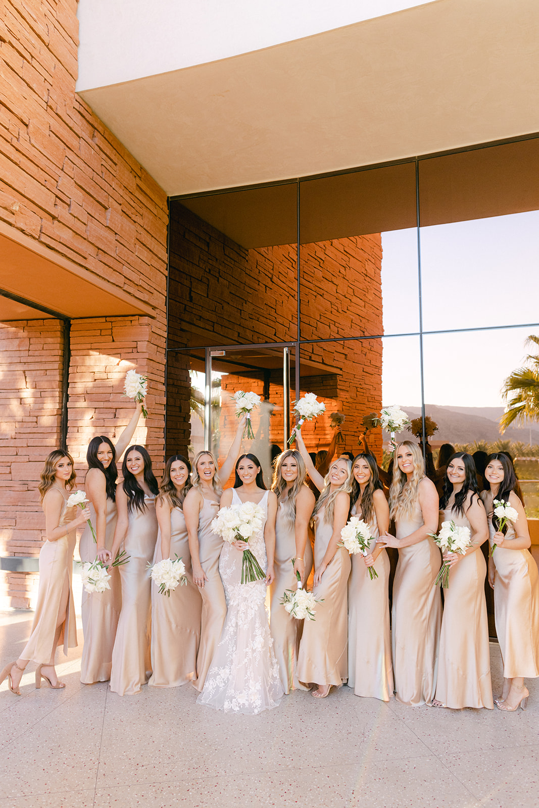 Wedding party and bride with all white rose bouquets and champagne bridesmaid dresses 