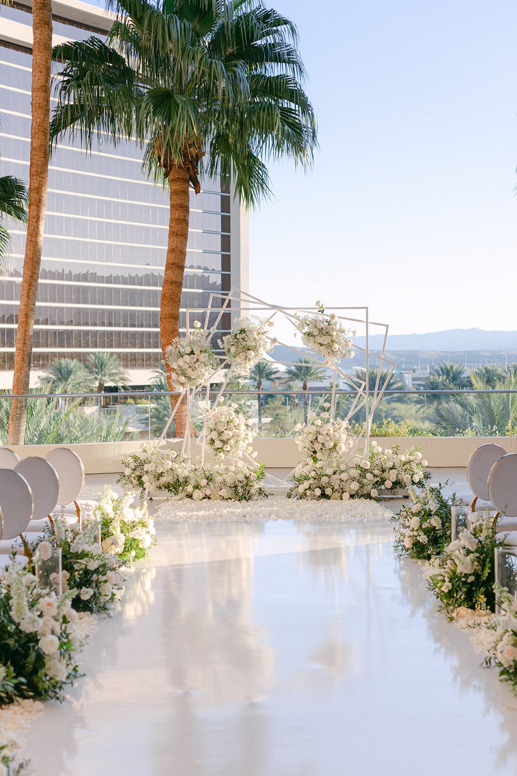 Geometric white ceremony arch with white rose floral and baby's breath design in Las Vegas 