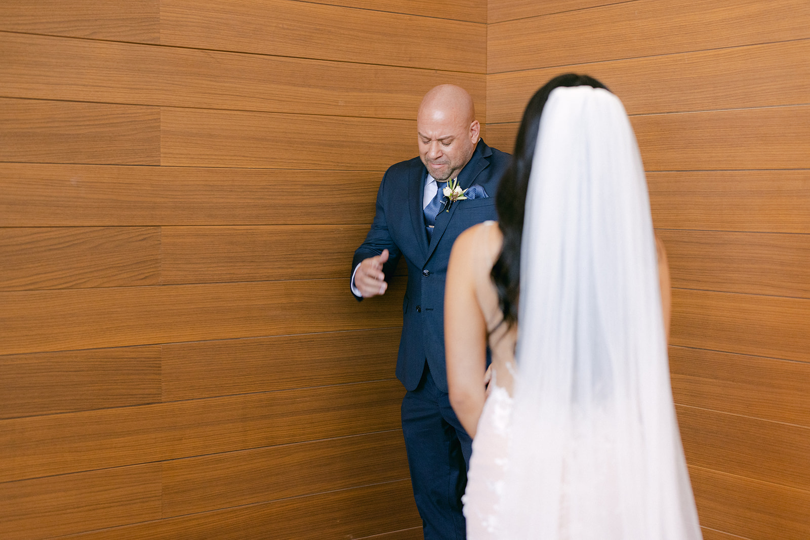 Father turning round for first look with daughter on wedding day 