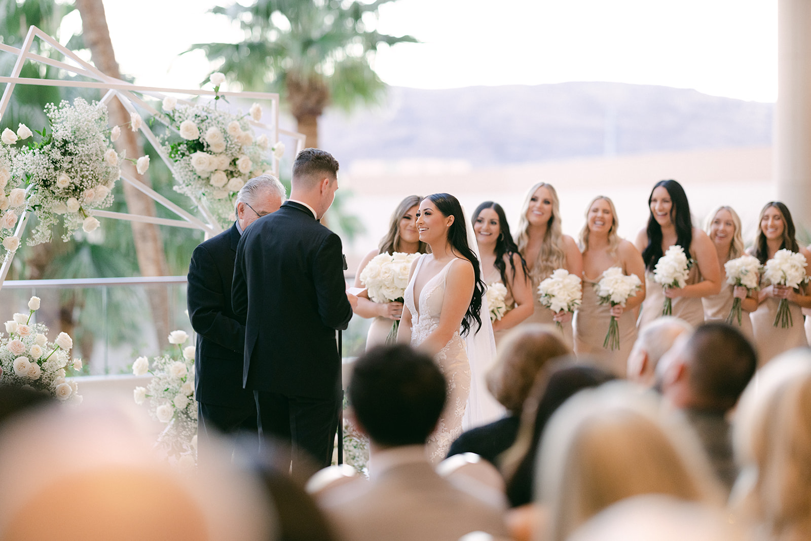 Bride and bridesmaids smiling during vows 