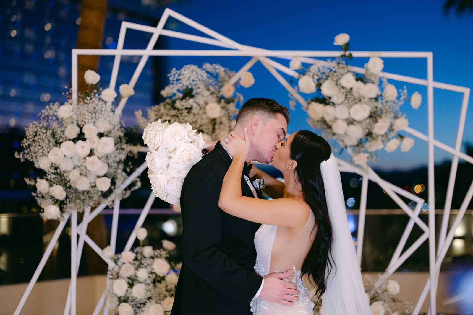 Newlyweds Kissing in front of Modern Geometric Arch fro Red Rock Casino Timeless Modern Wedding 