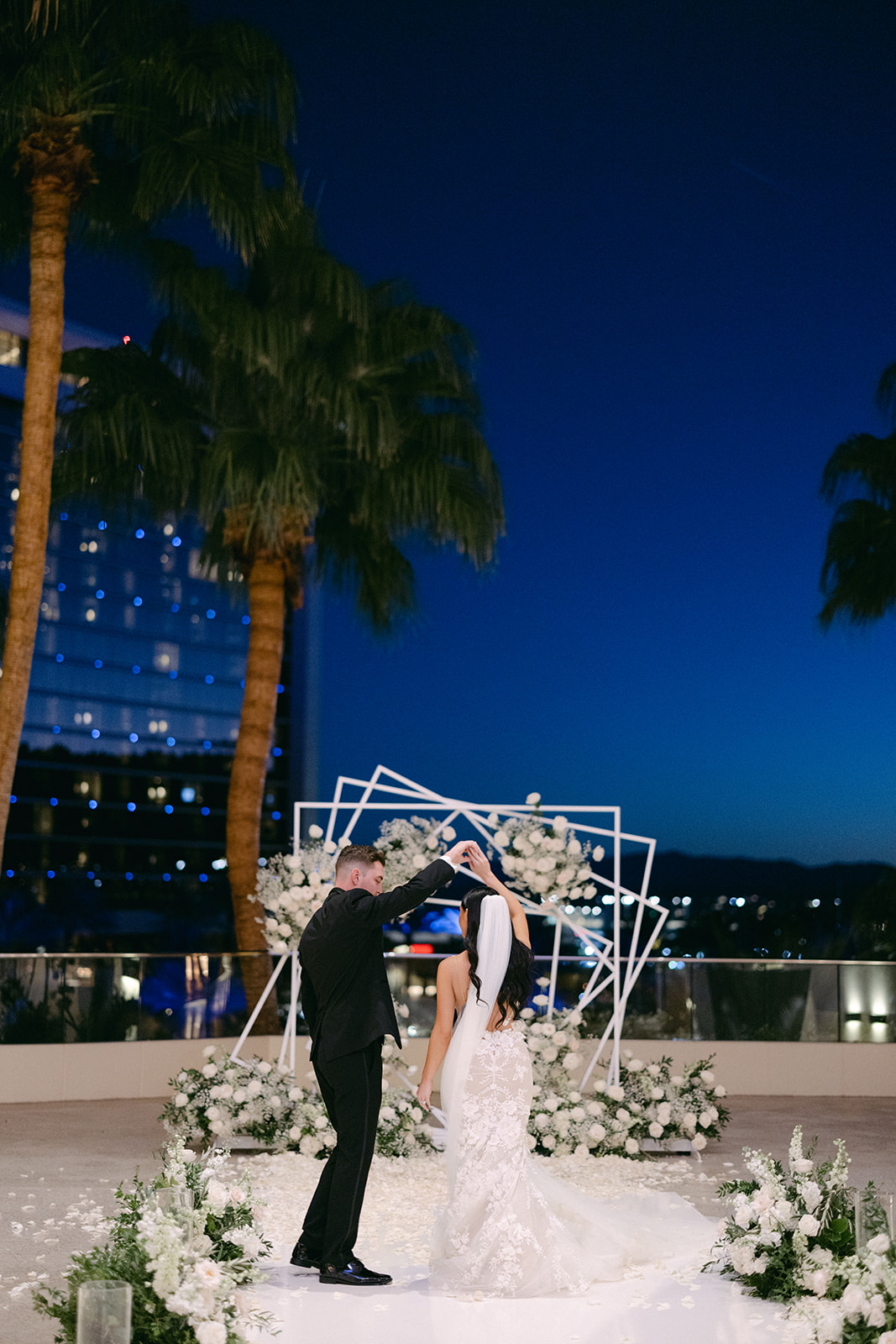 Bride and Groom dancing with palm trees and night sky in background 