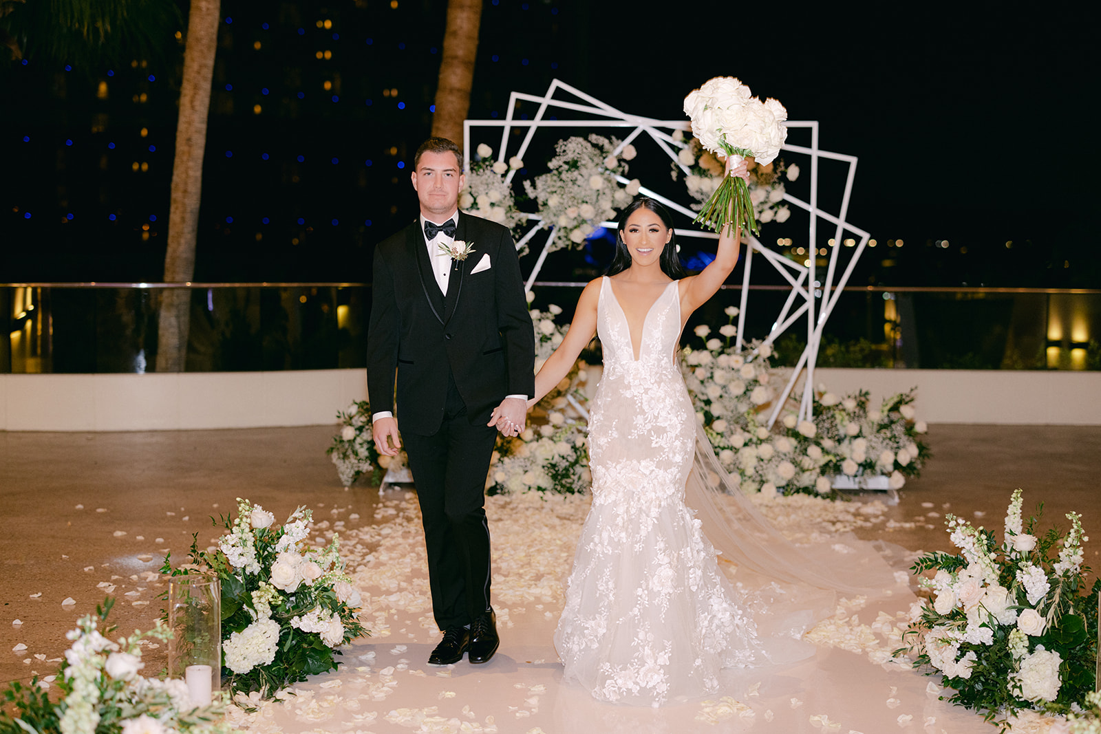 Groom and Bride celebrating holding up bouquet and walking 