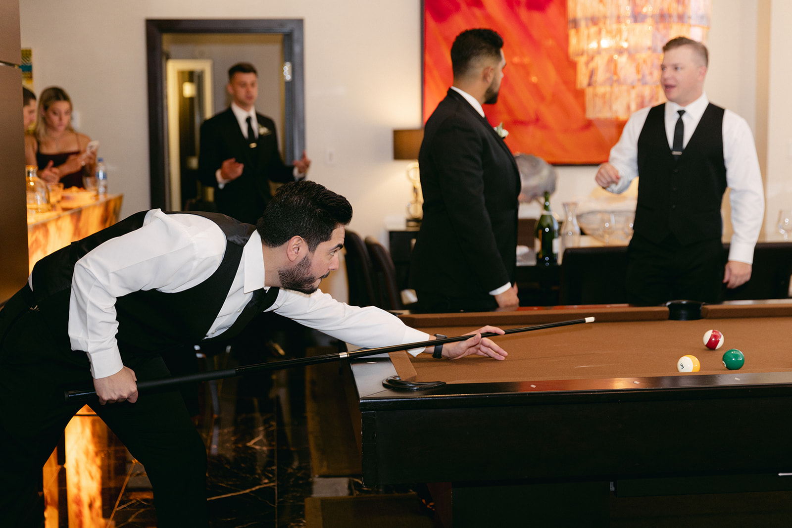 Groomsmen playing pool while waiting for wedding ceremony 