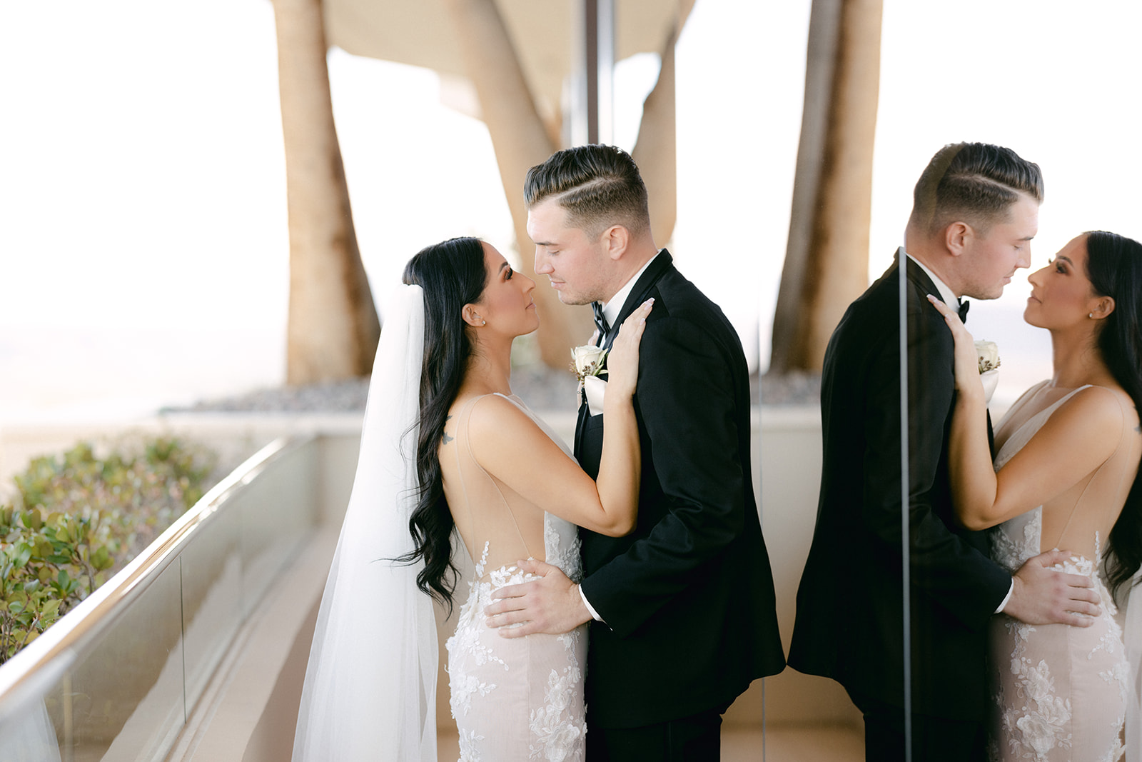 Bride and groom on balcony at Red Rock Casino with reflection on the window 
