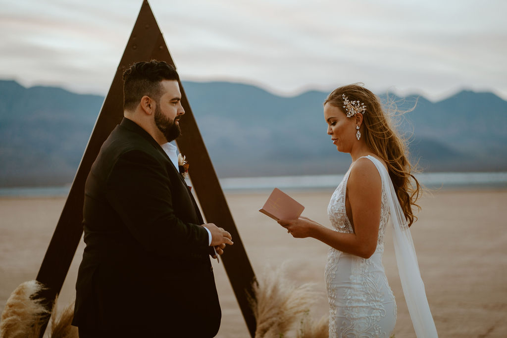 Bride Reading Vows to Groom by Triangle Arch 