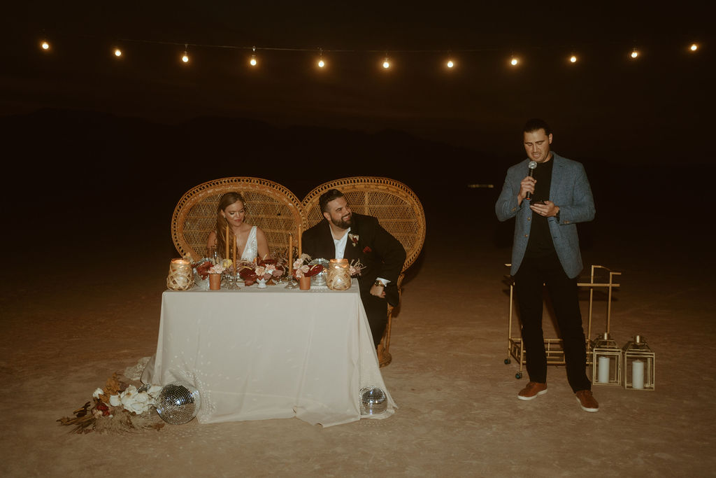 Man doing Speech next to Couple at Sweetheart Table in Las Vegas Desert