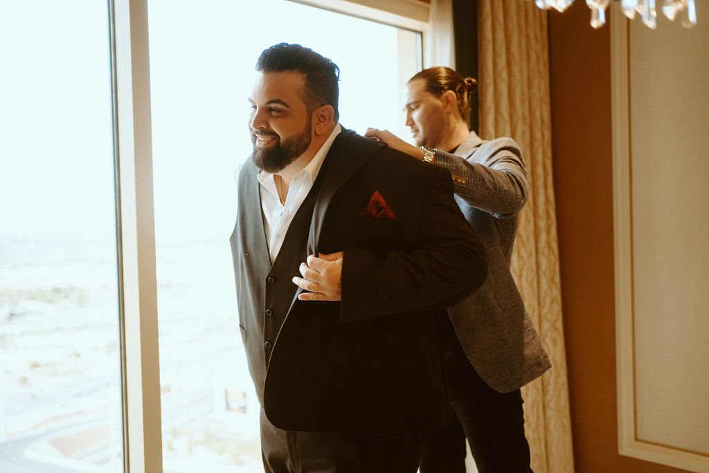 Groom putting on Jacket while Getting Ready to Be Married in Las Vegas 