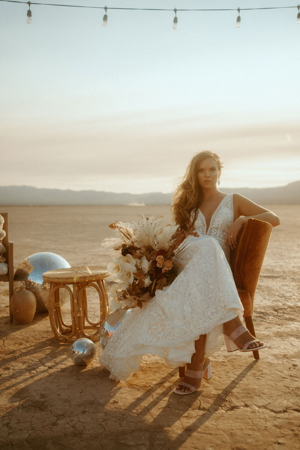 Bride Sitting in Desert Lounge with Bouquet and Disco Balls at Retro Disco Bohemian Micro-Wedding