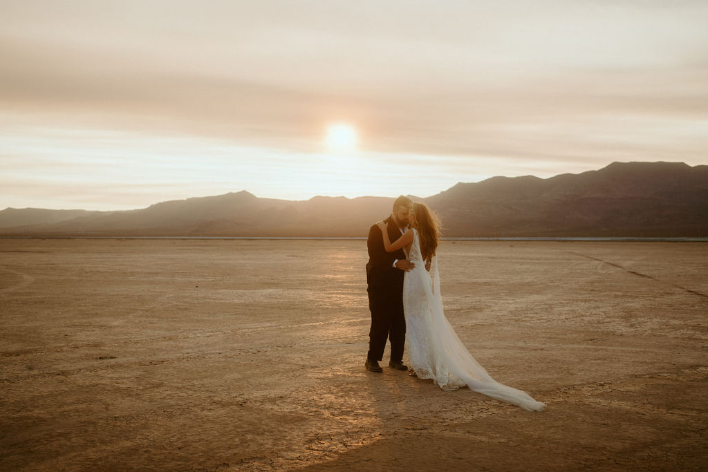 Bride and Groom Standing while Sun Sets in Las Vegas Dry Lake Bed 