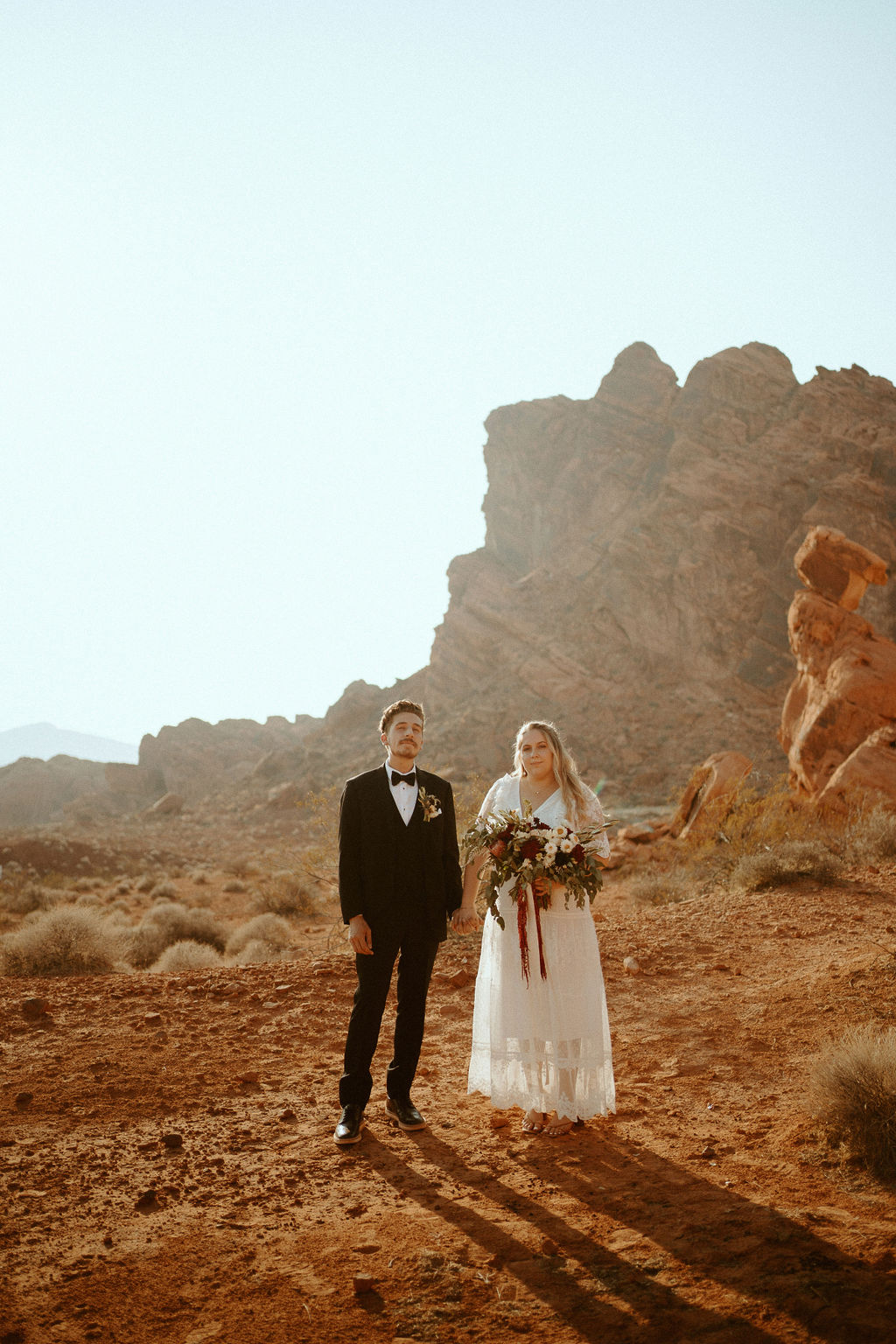 Newlyweds Standing in Dramatic Valley of Fire Scenery during Rolling out in Style in the Desert Elopement 