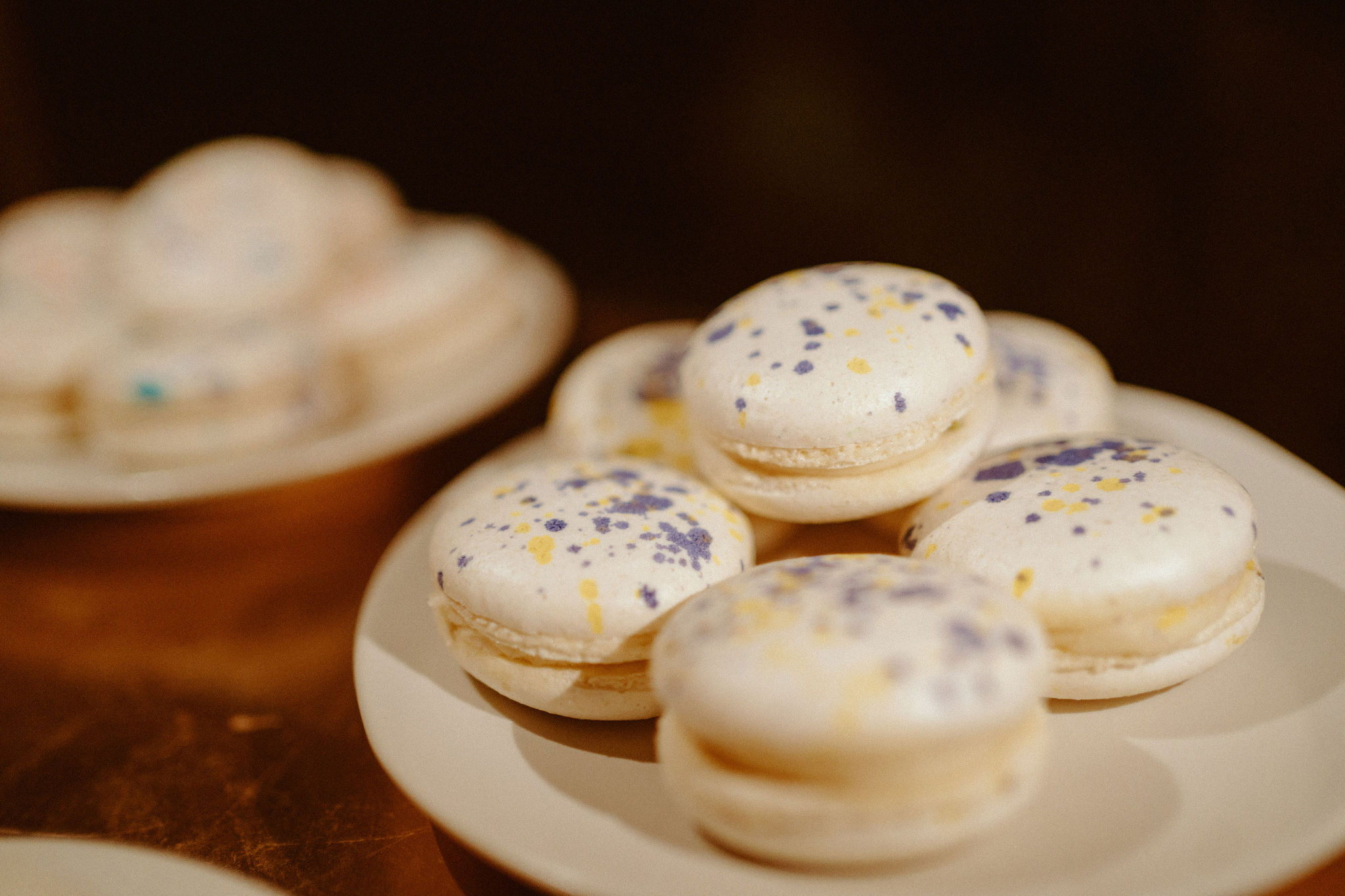 White macaroons with the wedding color palette splatters on top