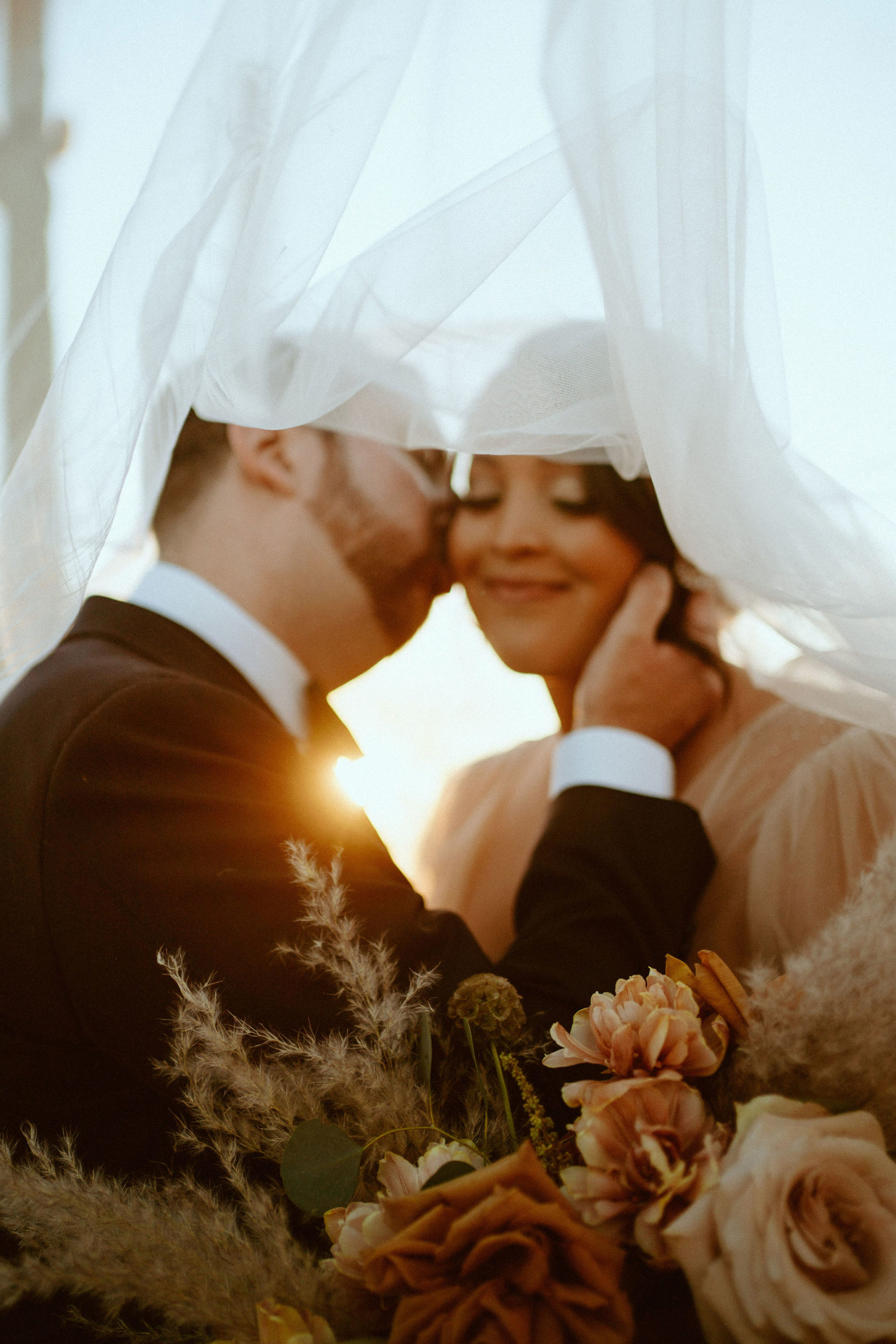 Saguaro National Park Micro-Wedding. The groom kissing the brides cheek under her veil