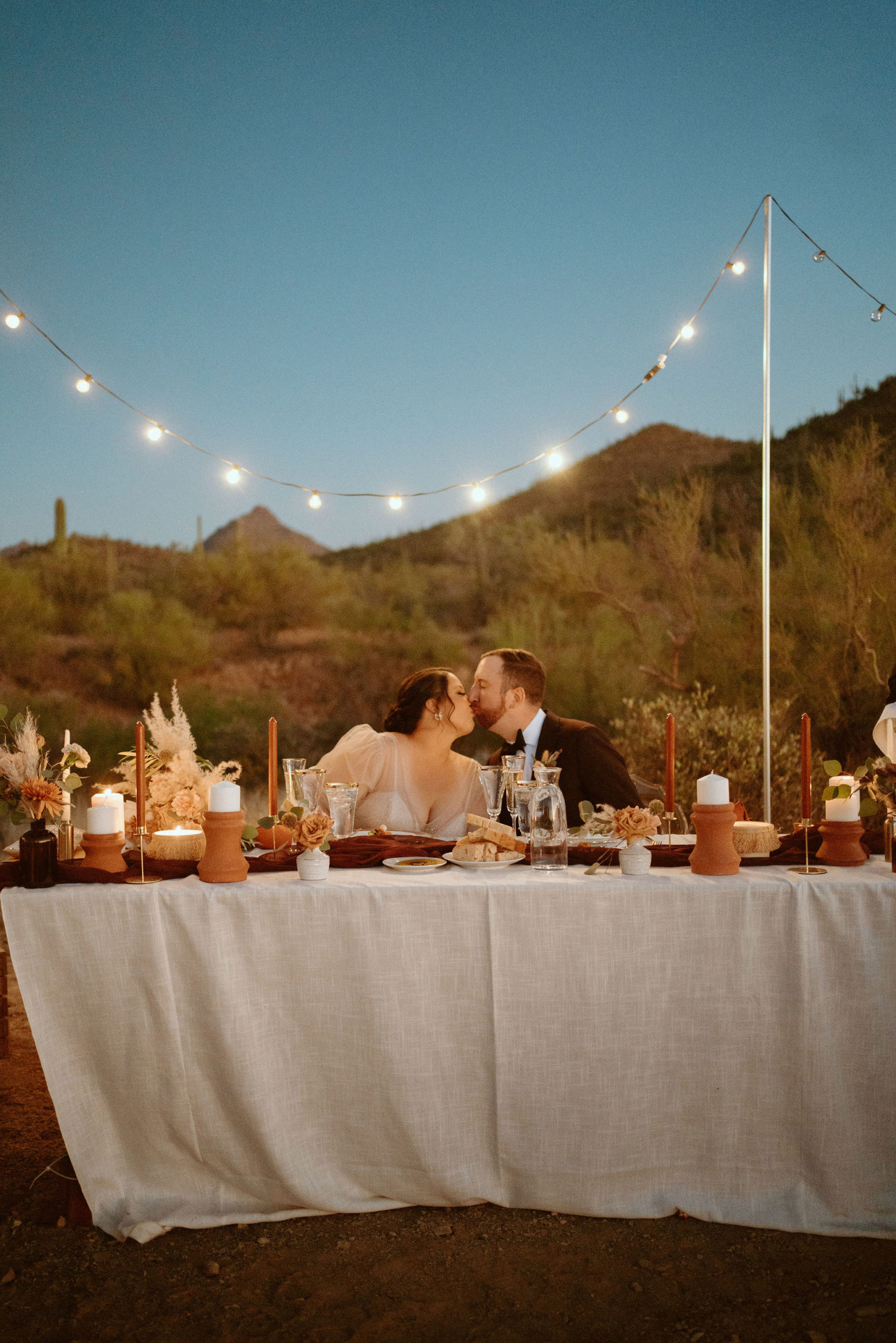 Saguaro National Park Micro-Wedding. The newlyweds kiss at the sweetheart table in the middle of the desert