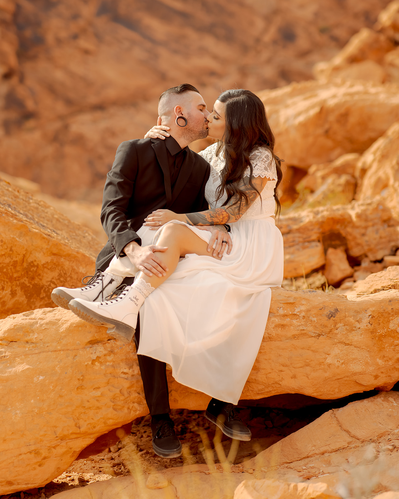 Newlyweds Sitting on Rock and Kissing in Valley of Fire Rock N Roll Wedding