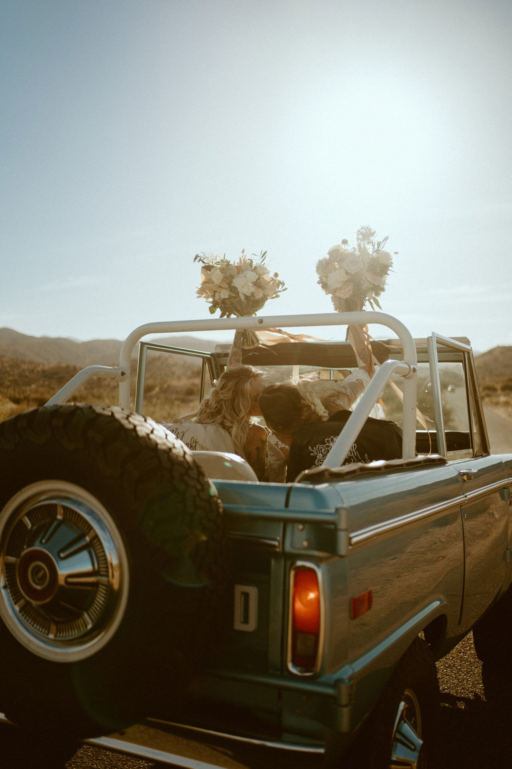 brides kissing in back of ford bronco 