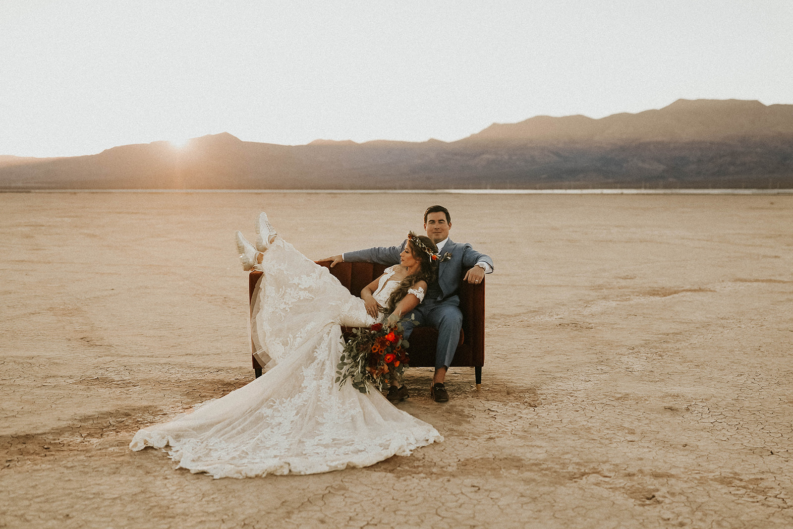 Newlyweds on Velvet Couch during Sunset in Dry Lake Bed Fall Inspired Elopement in Las Vegas