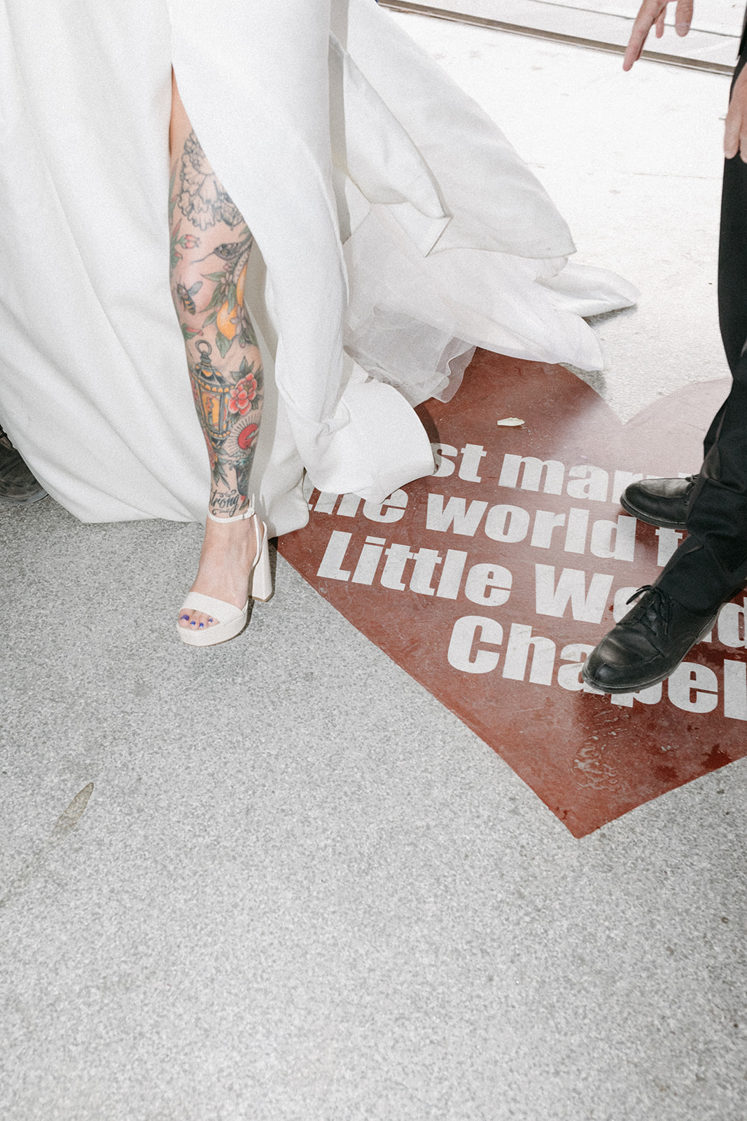 Bride's White Dress with Slit and Block Heels over "Just Married at the world famous Little White Wedding Chapel" heart on the ground 