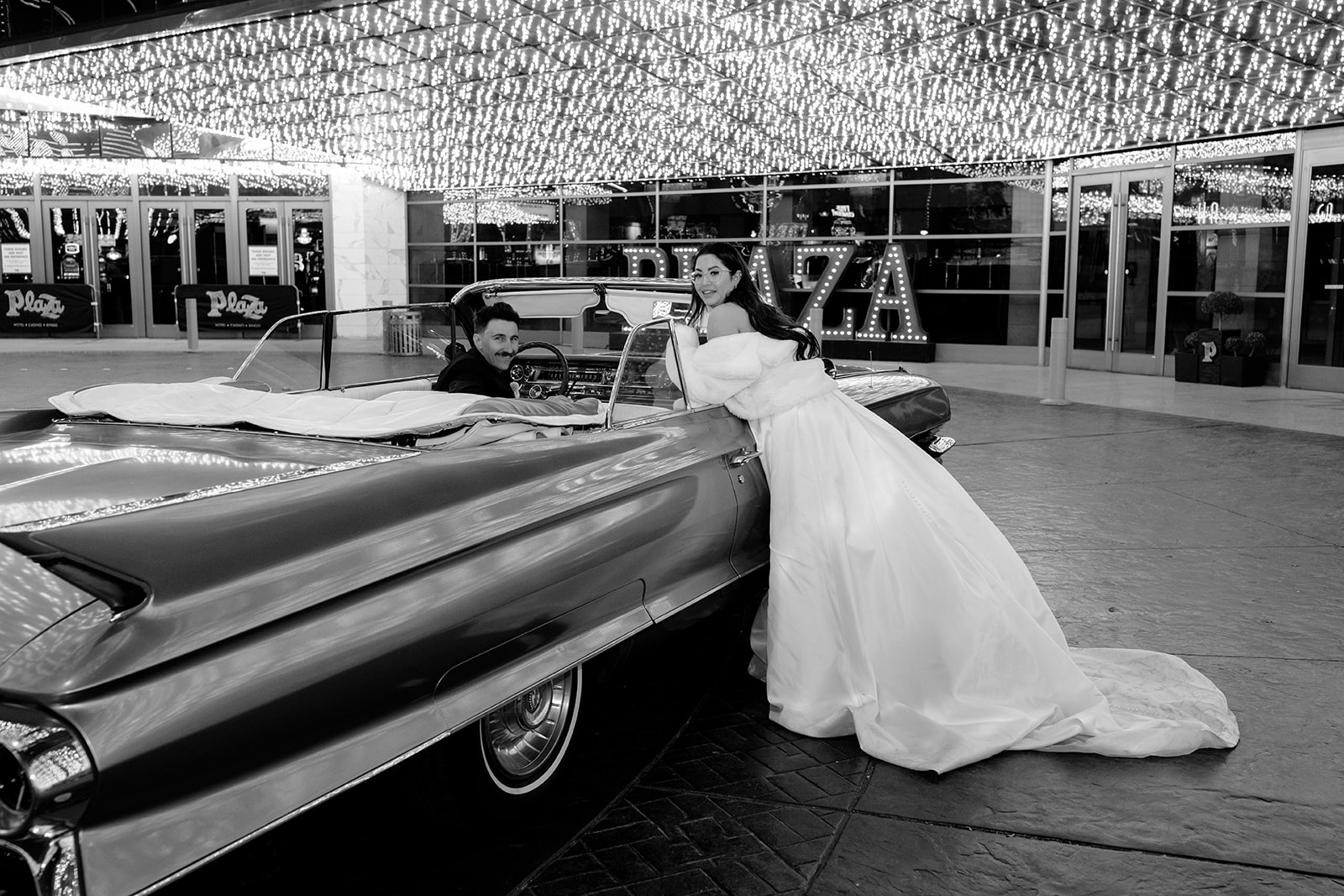 Bride Leaning on Classic Car while Groom in Drivers Seat Parked at Las Vegas Hotel 