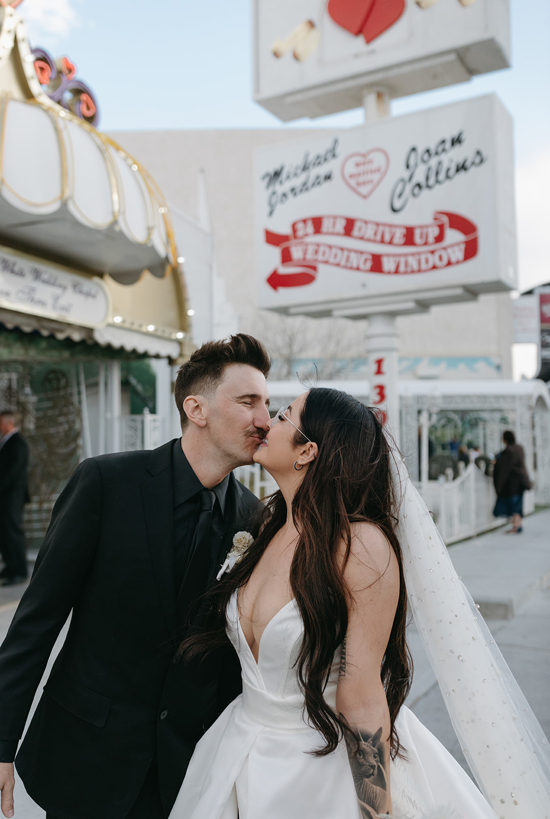 Newlyweds Kissing under Classic Las Vegas Chapel Sign after Ceremony 