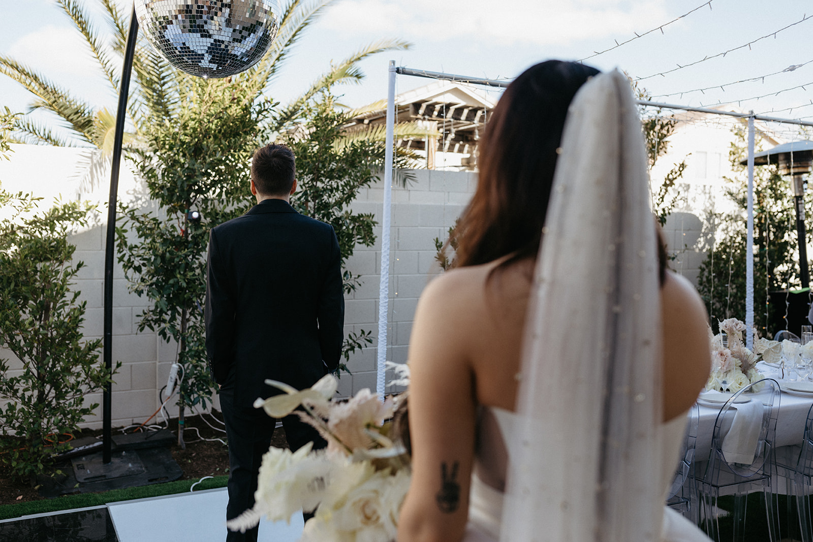 Groom under Disco Ball waiting to turn around for first look in modern Las Vegas wedding 