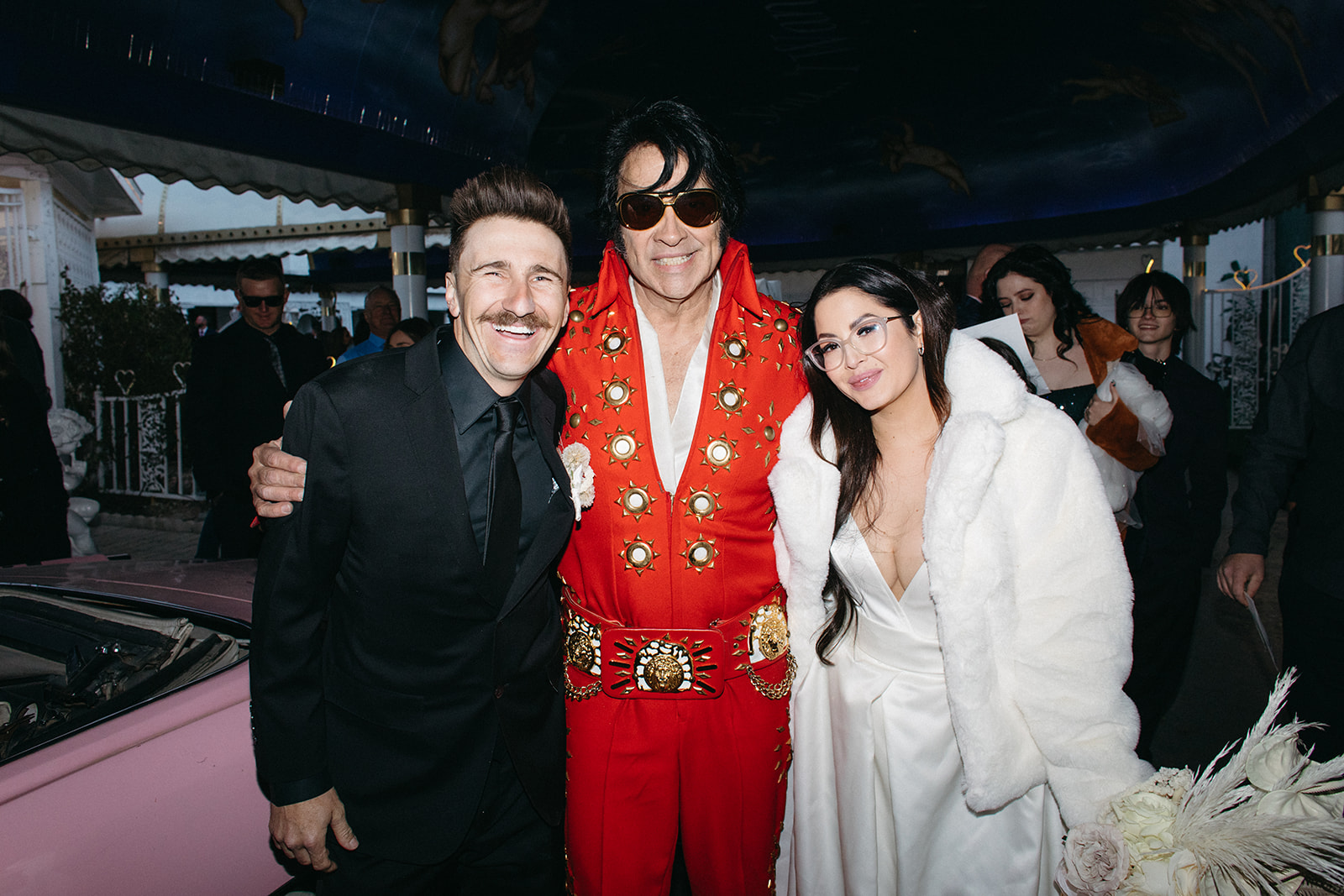 Groom & Bride in White Fur Coat with Elvis Officiant after Ceremony in Las Vegas 